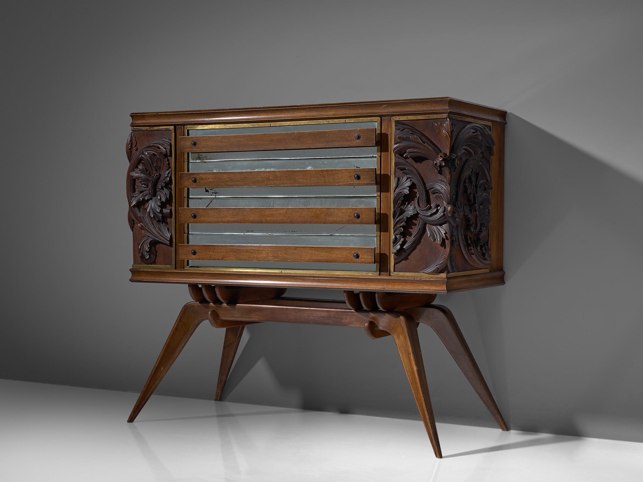 Italian elegant sideboard in oak originates from the 1940s. The two outer door panels show a very detailled relief of floral motifs, which give this sideboard an expressive touch. Behind the carvings storage facility can be found on each side.