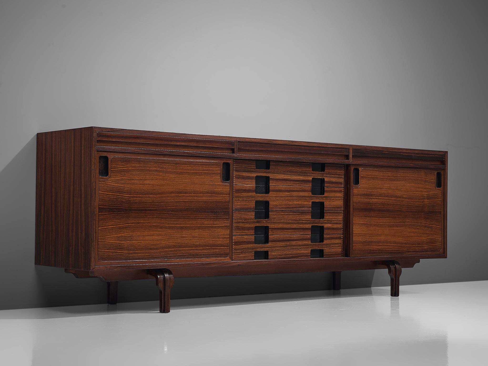 Luigi Massoni, sideboard, rosewood, Italy, 1960s.

This Italian credenza, designed by Luigi Massoni in the sixties, is executed in rosewood. It consist of two sliding doors with characteristic black round inlayed handles, and four drawers. The