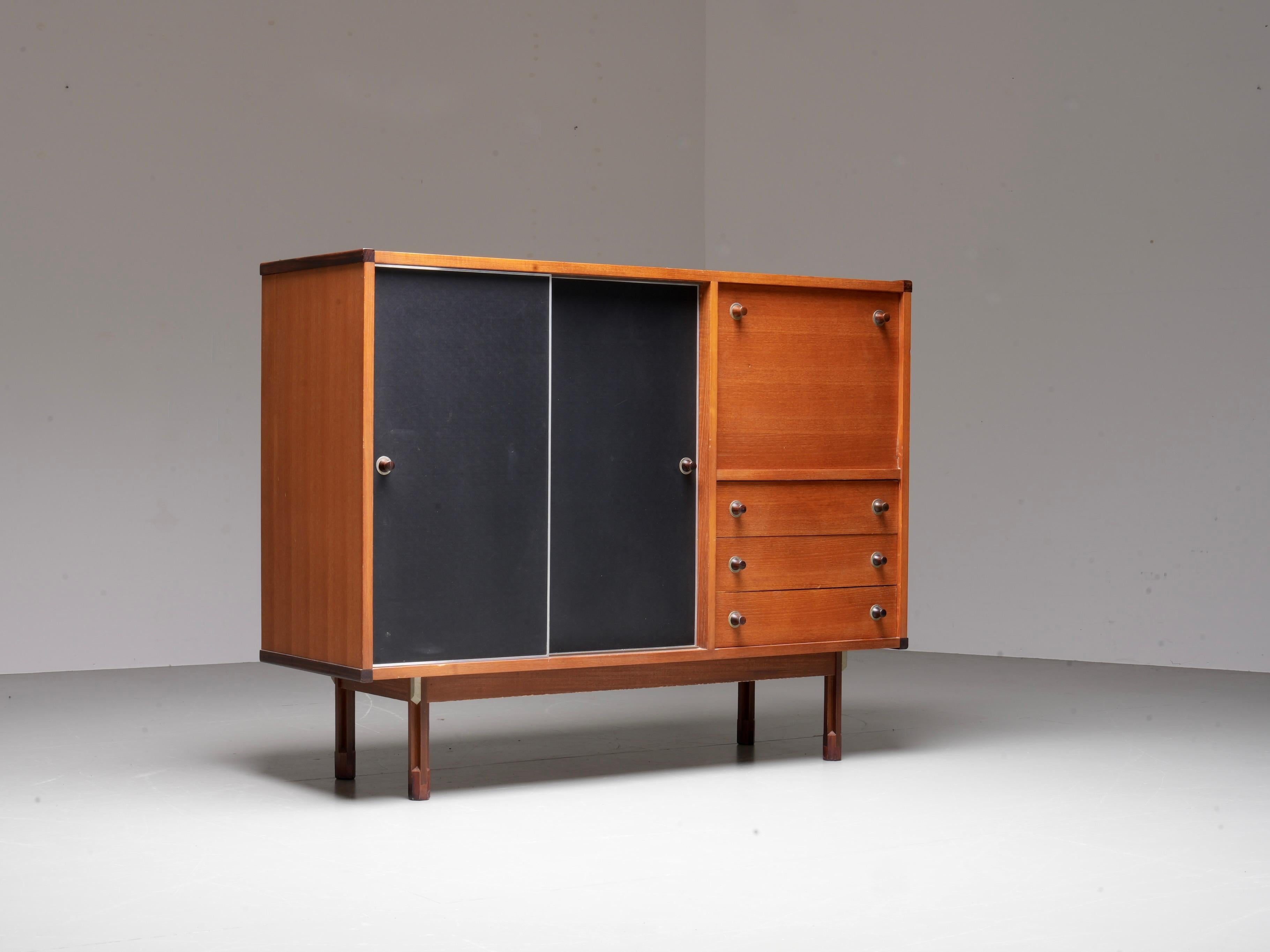 Italian Cabinet / Secretary in Teak, Metal and Black Laminate, 1960's.

Versatile and elegant, this 1960s Italian cabinet combines functionality with refined details. The piece is primarily crafted from teak, with a base made of another dark wood,