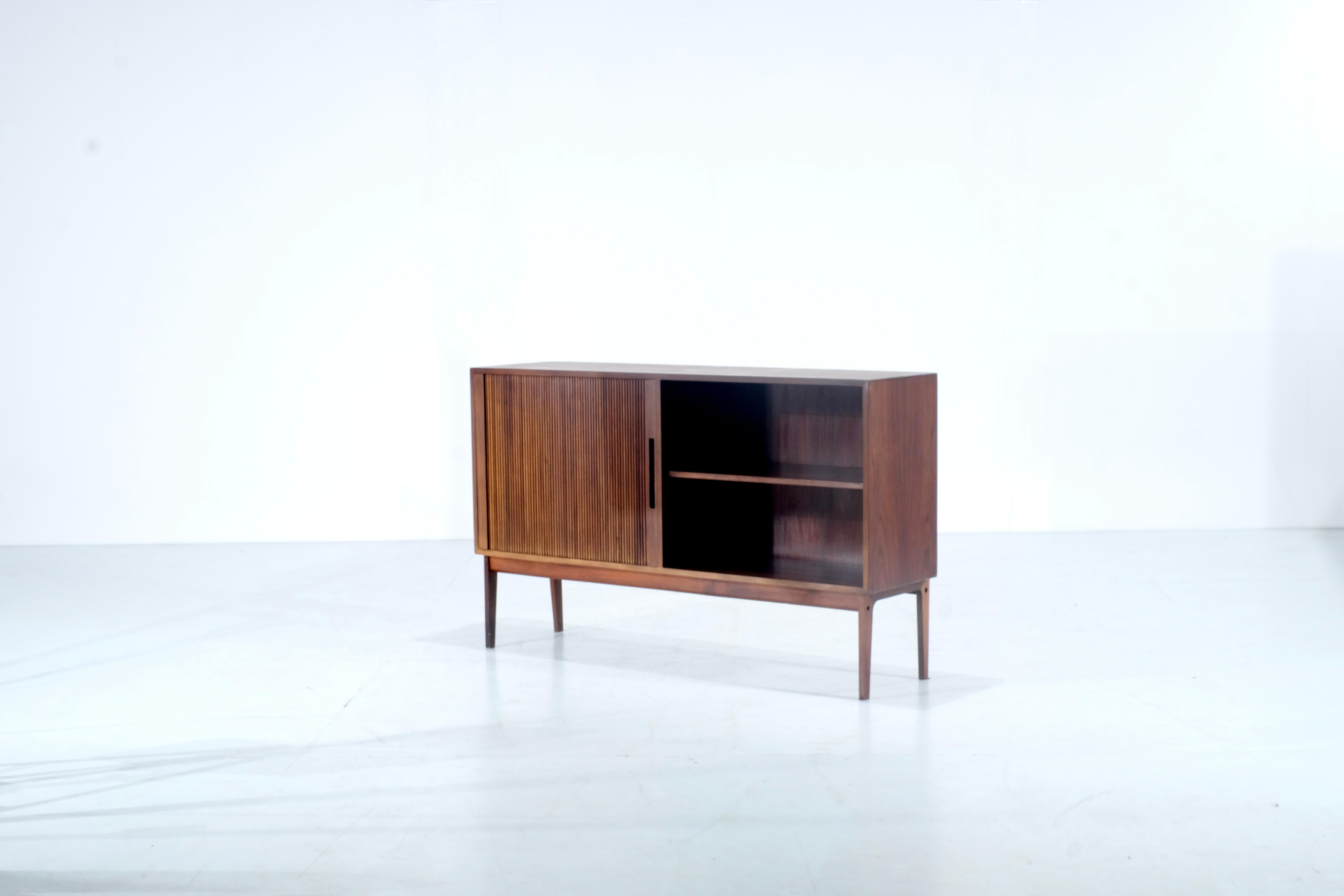 Amazing italian sideboard from 1970
this great shaped sideboard has a sliding wooden door and the other side has no door  which bring an amazing design. This type of sliding door reminds us of Frattini furniture. ( Note that this sideboard is not