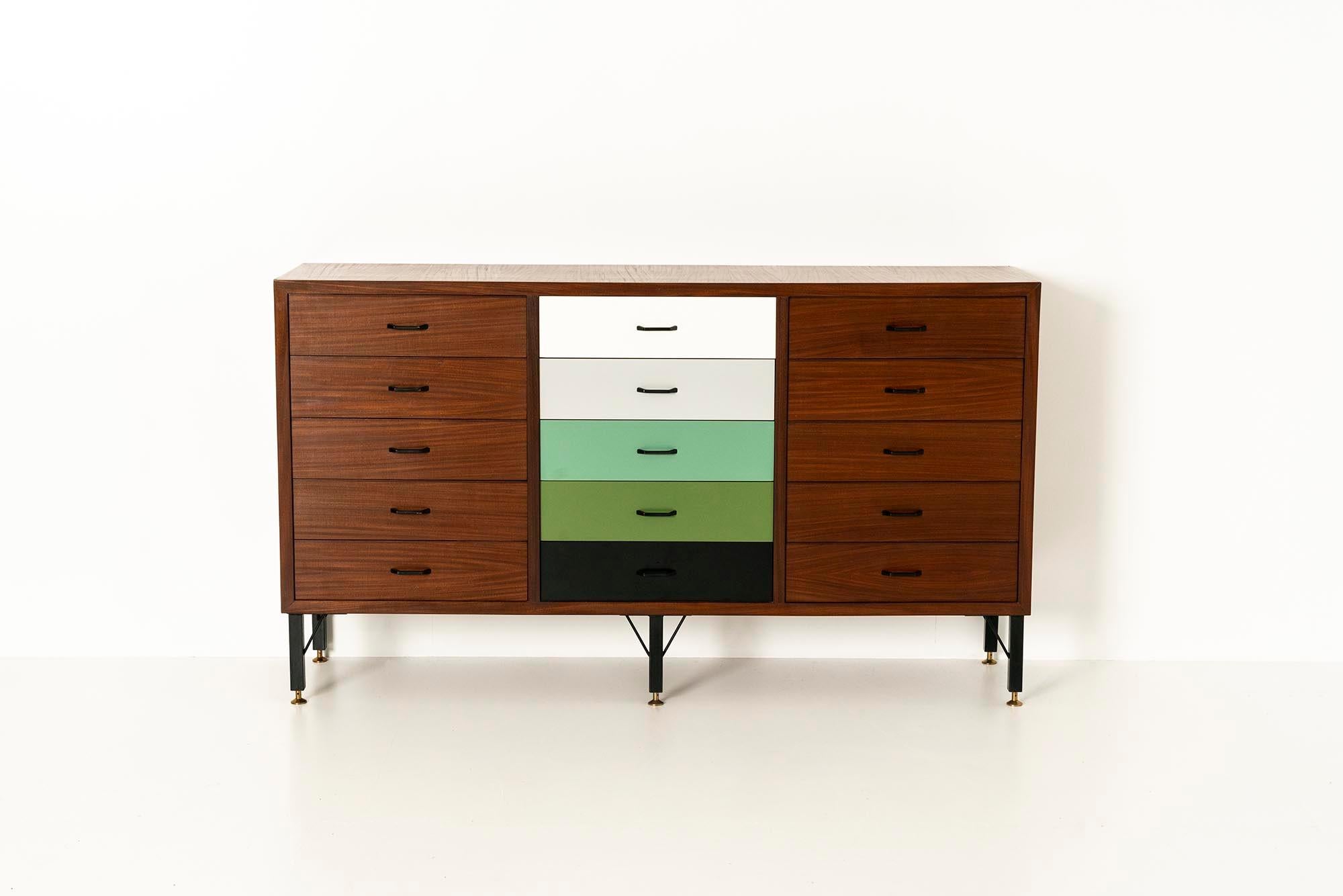 A playful Italian sideboard with a teak veneer finish supported by a rather architectonic metal frame reminiscent of a main supporting structure of a building. The feet are finished in brass and allow for a daring contrast with regard to the tightly