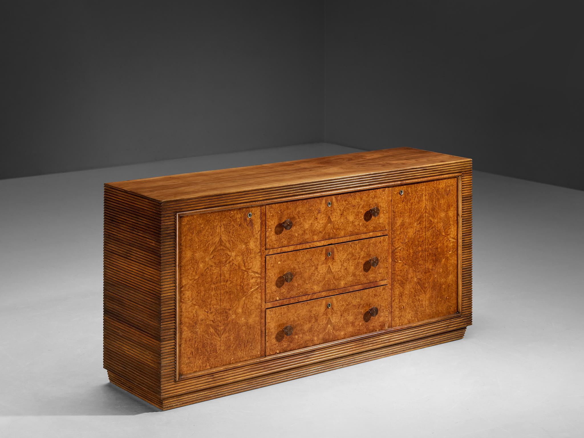 Sideboard, walnut, walnut burl, Italy, 1940s

This sideboard, a true gem of Italian Art Deco design, brings a touch of elegance and beauty to one's interior space. The cabinet features exquisite details, such as the grissinato carvings: delicate