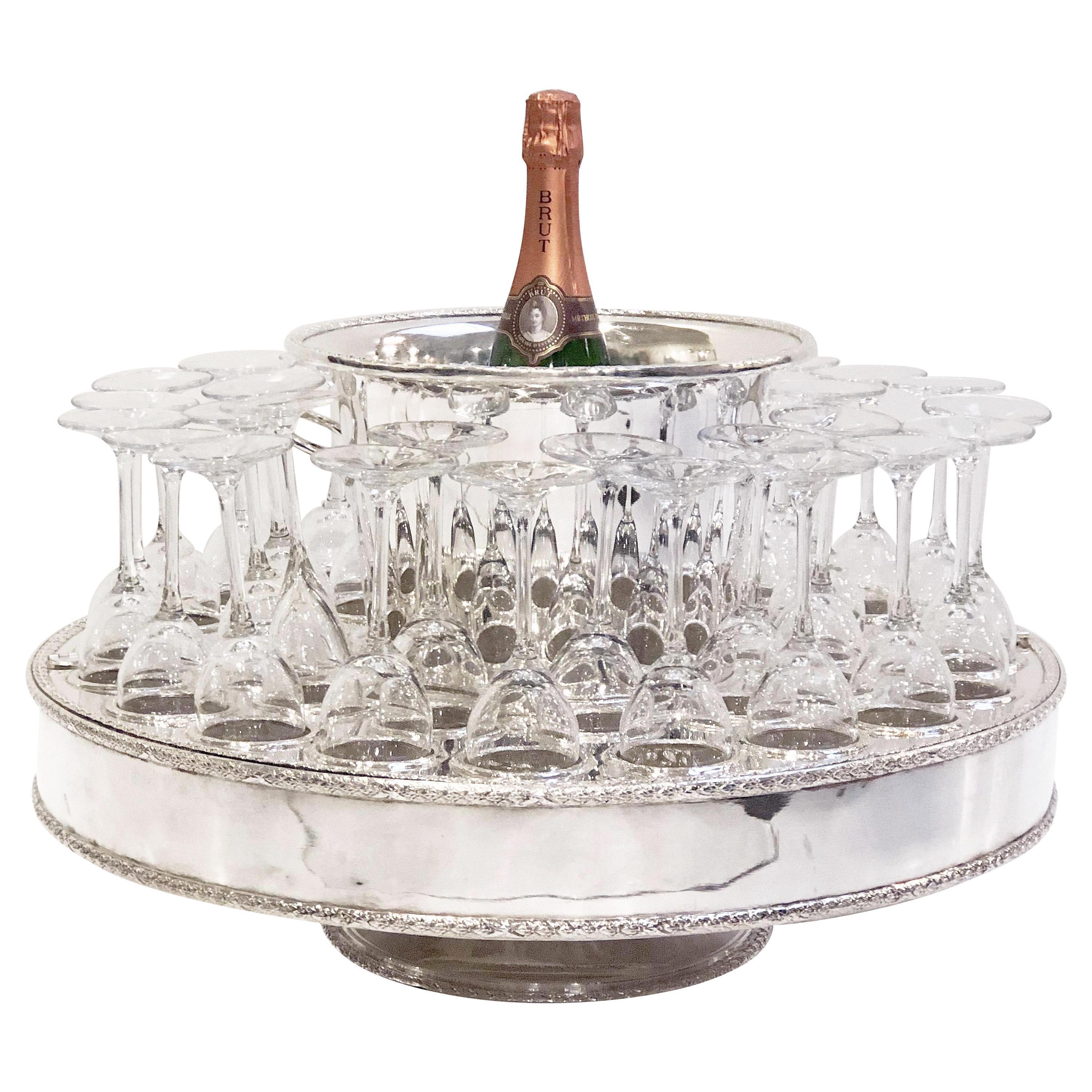 A fine Italian champagne service or presentation centerpiece, featuring a round revolving stand (or lazy susan) of plate silver, with fitted spaces for holding thirty-two champagne flutes and a removable champagne or wine cooler in the inset