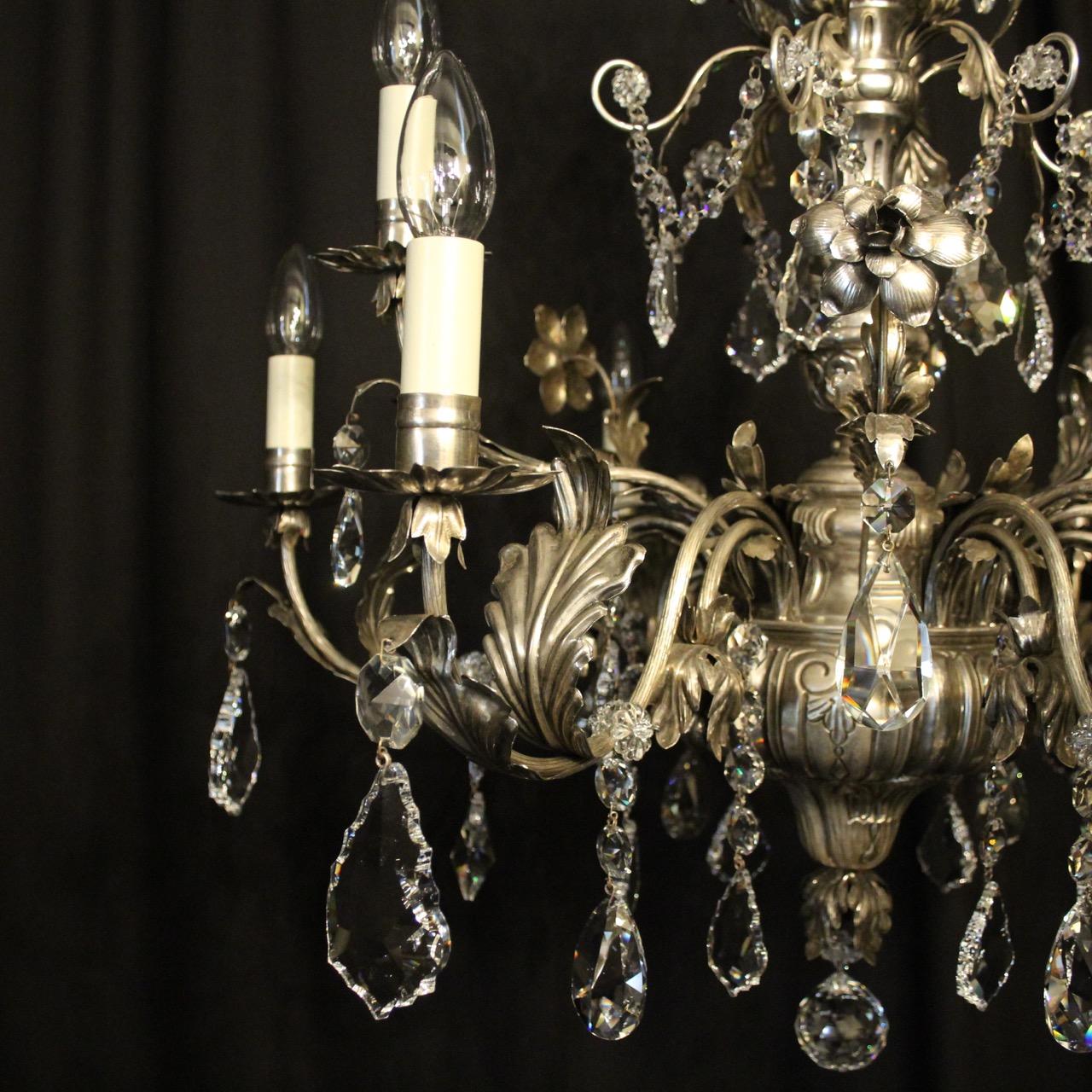 A decorative Italian Genoa silver metal 9-light double tiered chandelier, the reeded Acanthus leaf scrolling arms with pressed drip pans, issuing from a repousse decorated tapering baluster column and decorated overall with quality Swarovski crystal