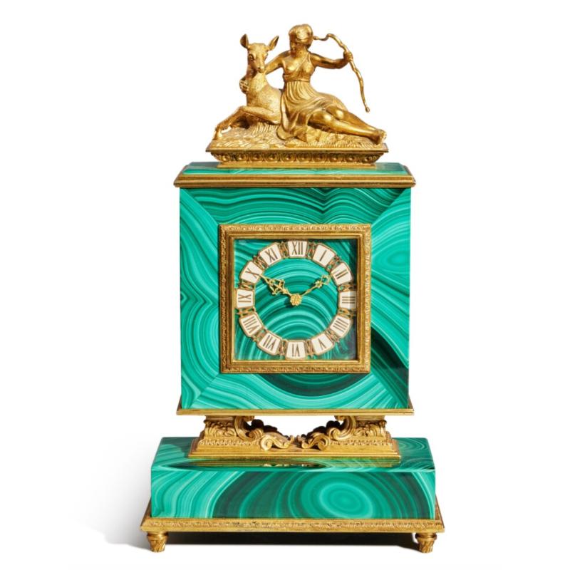 An Italian silver-gilt and figural malachite desk clock, circa 1960.

Beautiful malachite case with 22k gold plated on .800 silver mounts, trim and figure of Diana the huntress holding a bow and seated nestled to a deer which is laying down. 

With