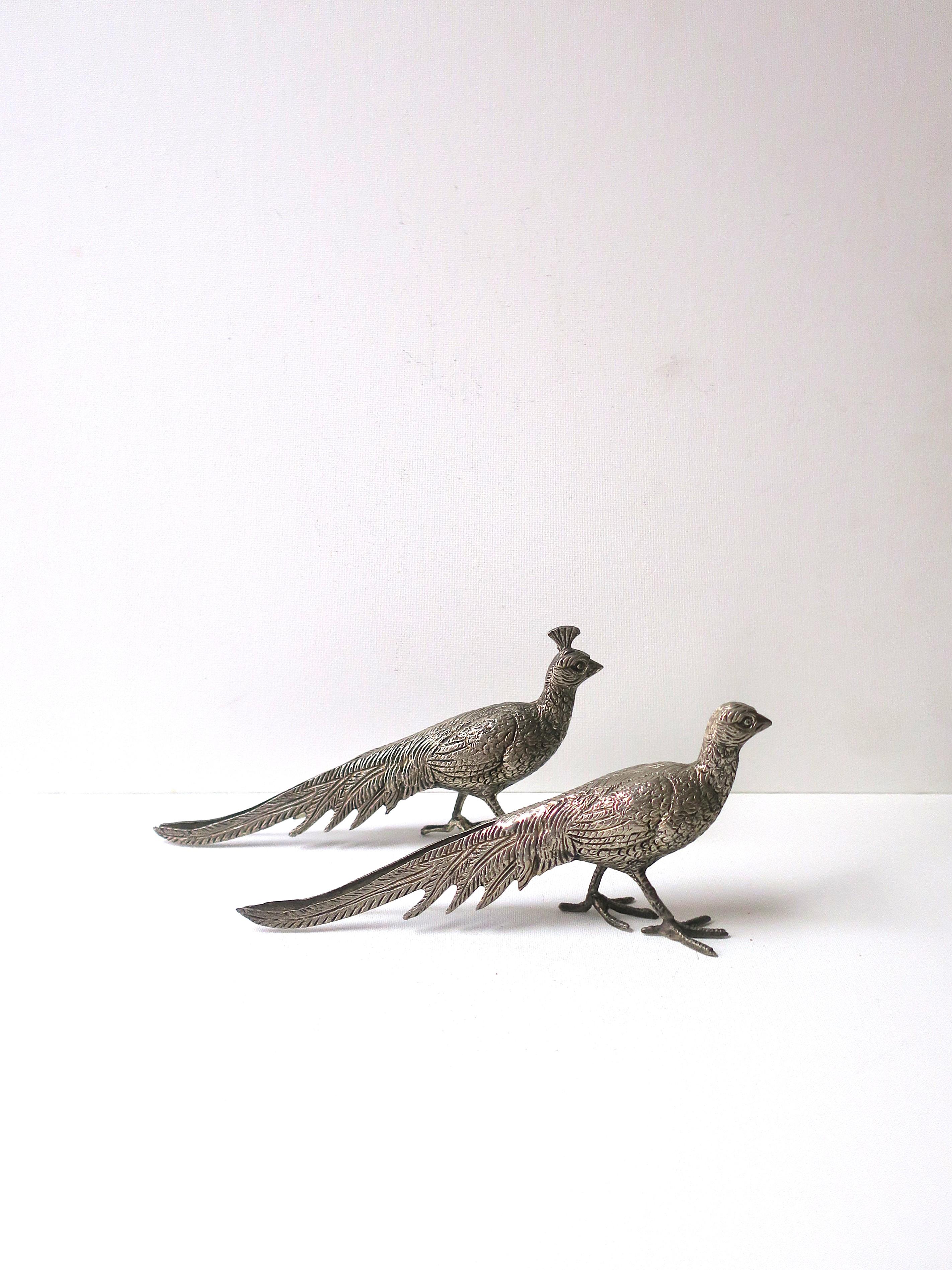 Pareja italiana de esculturas de pájaros faisanes en plata, objetos decorativos, hacia principios o mediados del siglo XX, Italia.  Los pájaros, macho y hembra, están bellamente fundidos con finos detalles y acabados con una capa de plata. Un gran