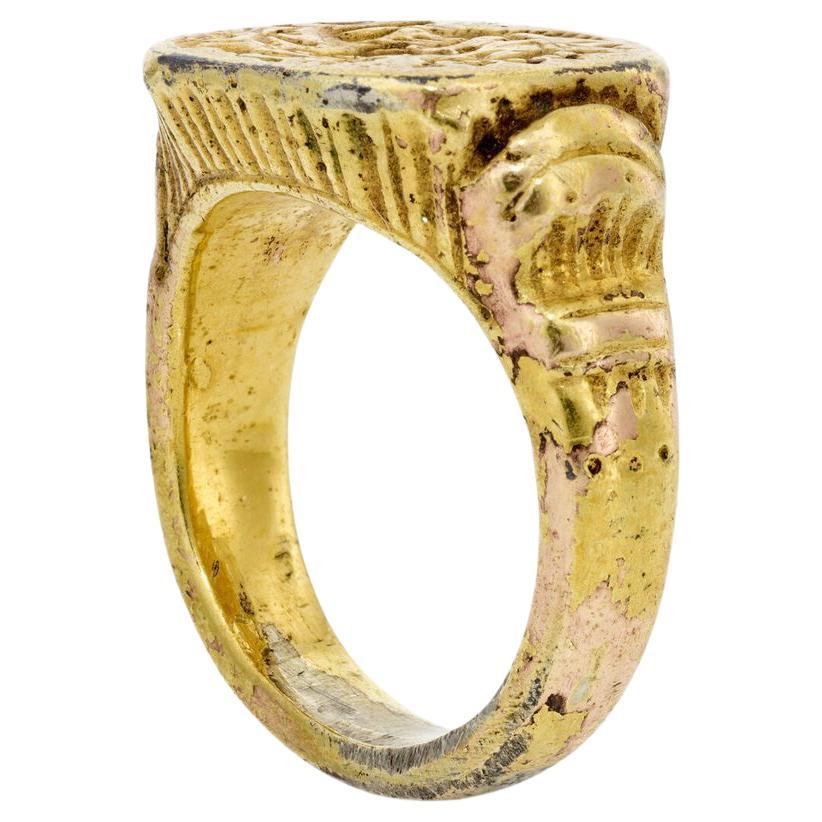 Anillo de sello

siglo XVIII

Silver, chapado en oro. El anillo presenta signos evidentes de desgaste. Tamaño del anillo: 9. Aproximadamente 19,7 g.

El gallo y el león flanquean una inicial enlazada (posiblemente HB). Sobre ella, una corona de