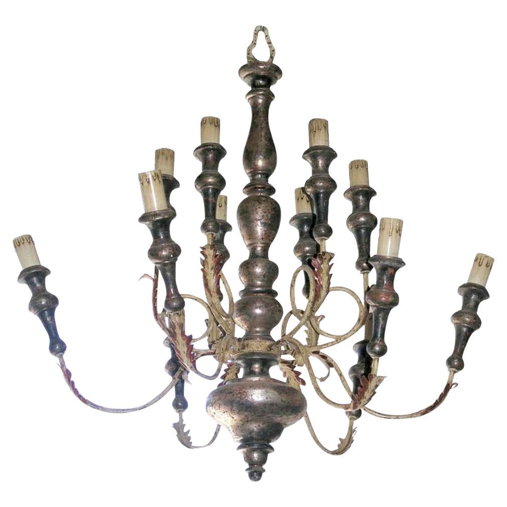 Parcel painted and silver giltwood chandelier. baluster standard issuing twelve tole scrolling arms painted and carved acanthus throughout