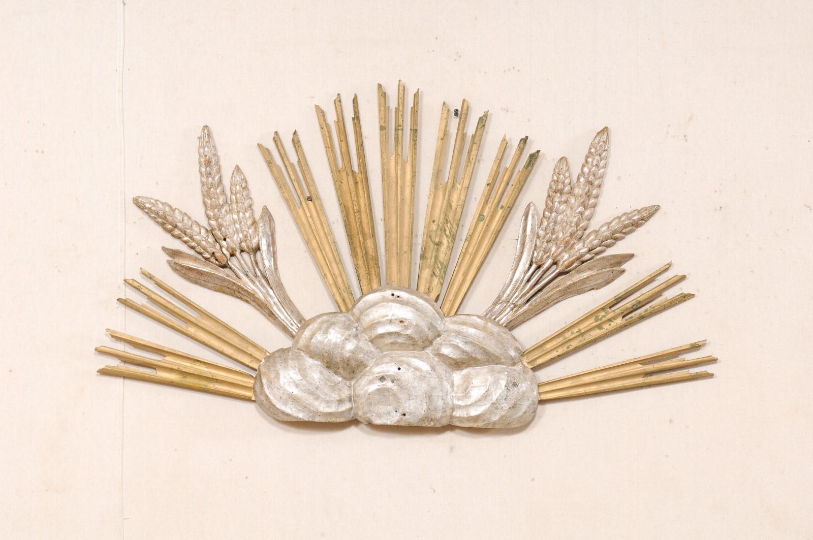 An Italian giltwood cloudy sunburst with rays and wheat from the 19th century. This antique wall ornament from Italy has been carved with a collection of swirling clouds grouped together at center, from which a series of carved and gold gilt rays