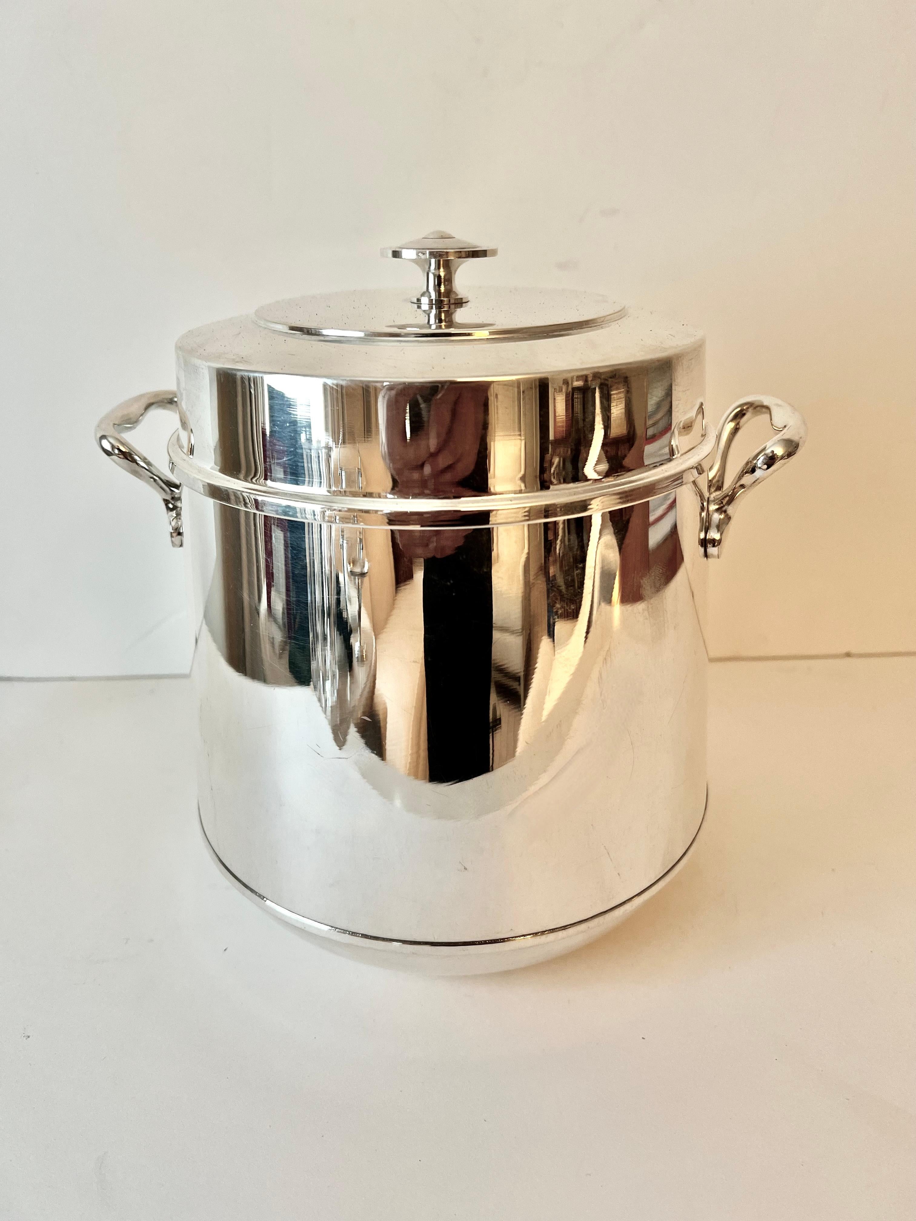 Silver Plated Ice Bucket with lid and handles - the interior is copper color thermal glass -

A very sophisticated addition to any bar or drink setting - The look is very sophisticated and while it is mid-century, it's a timeless look and feeling