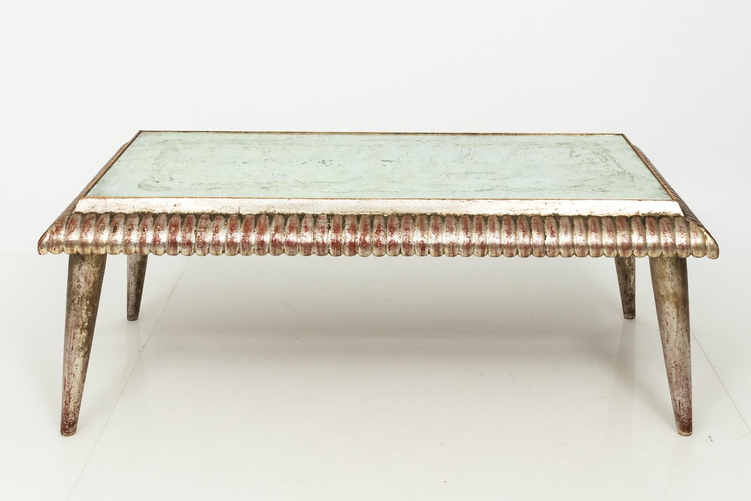 Italian silver leaf low table with mirrored top, carved gadroon trim, and plain tapered legs, circa 20th century.
      