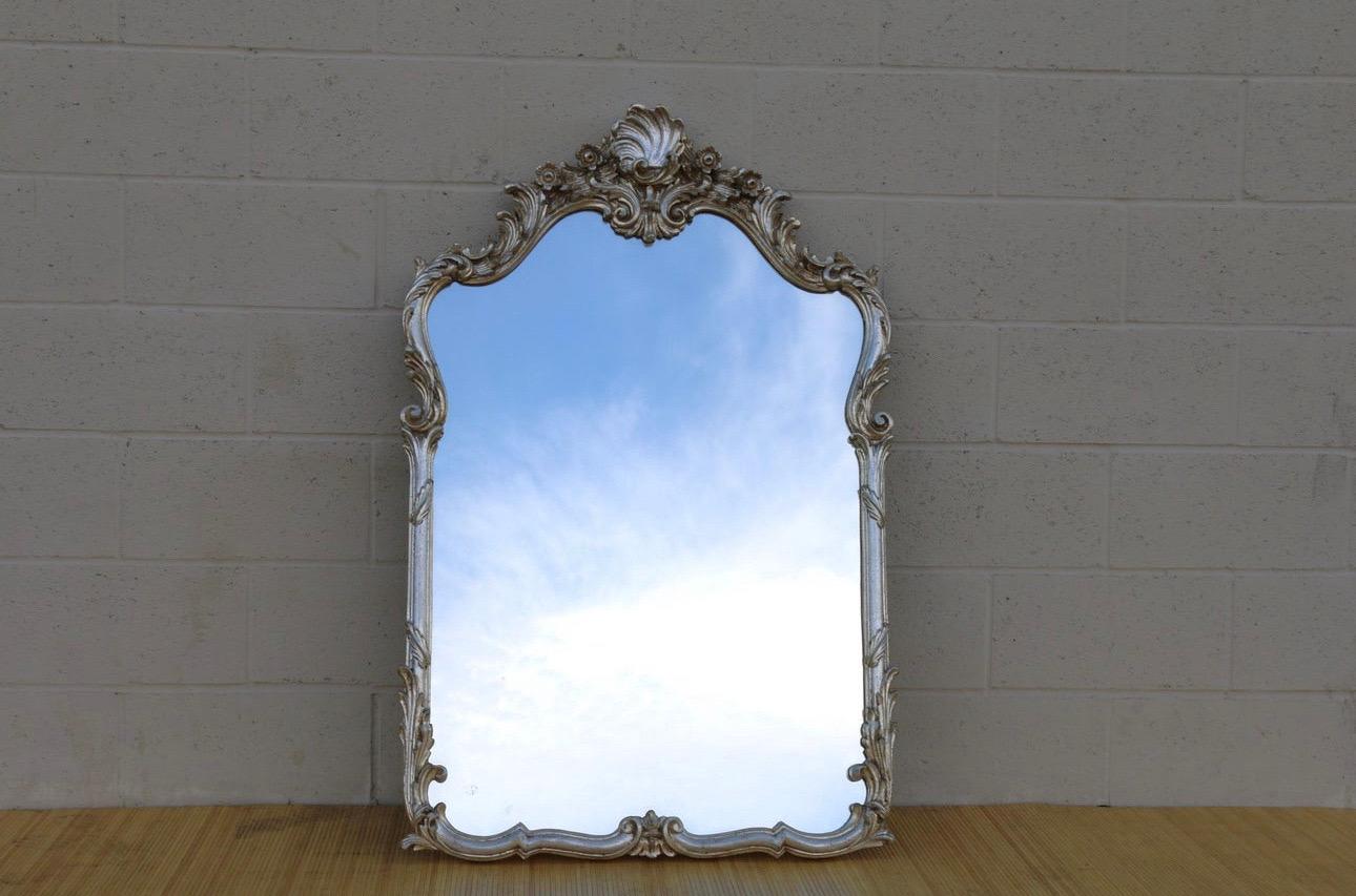 Spectacular silver leaf wall mirror made in Italy, it has the label in the back. Manufactured in the 1950’s. It is all wood and it has a beautiful carved shell seashell. The mirror is in good vintage condition. It has a little crack, not such a big