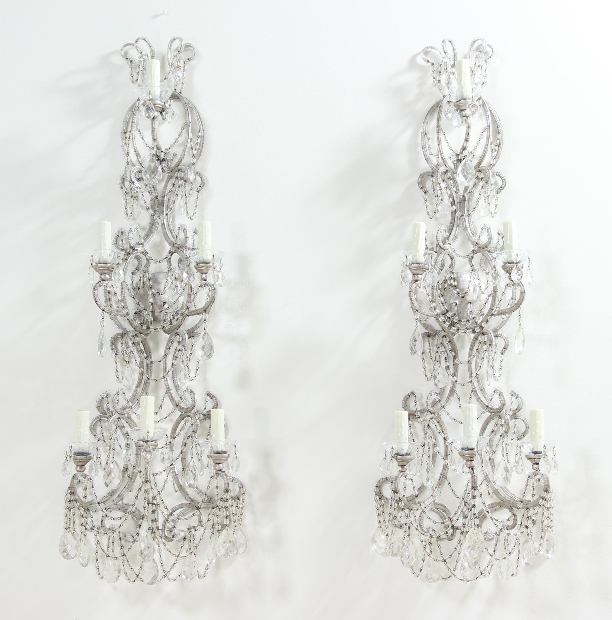 Magnificent, pair of Italian silvered iron and crystal beaded sconces.

These impressive and rare pair of sconces feature silver-leafed scrolled iron frames with crystal beading along their entirety. An abundance of “macaroni” glass beads and