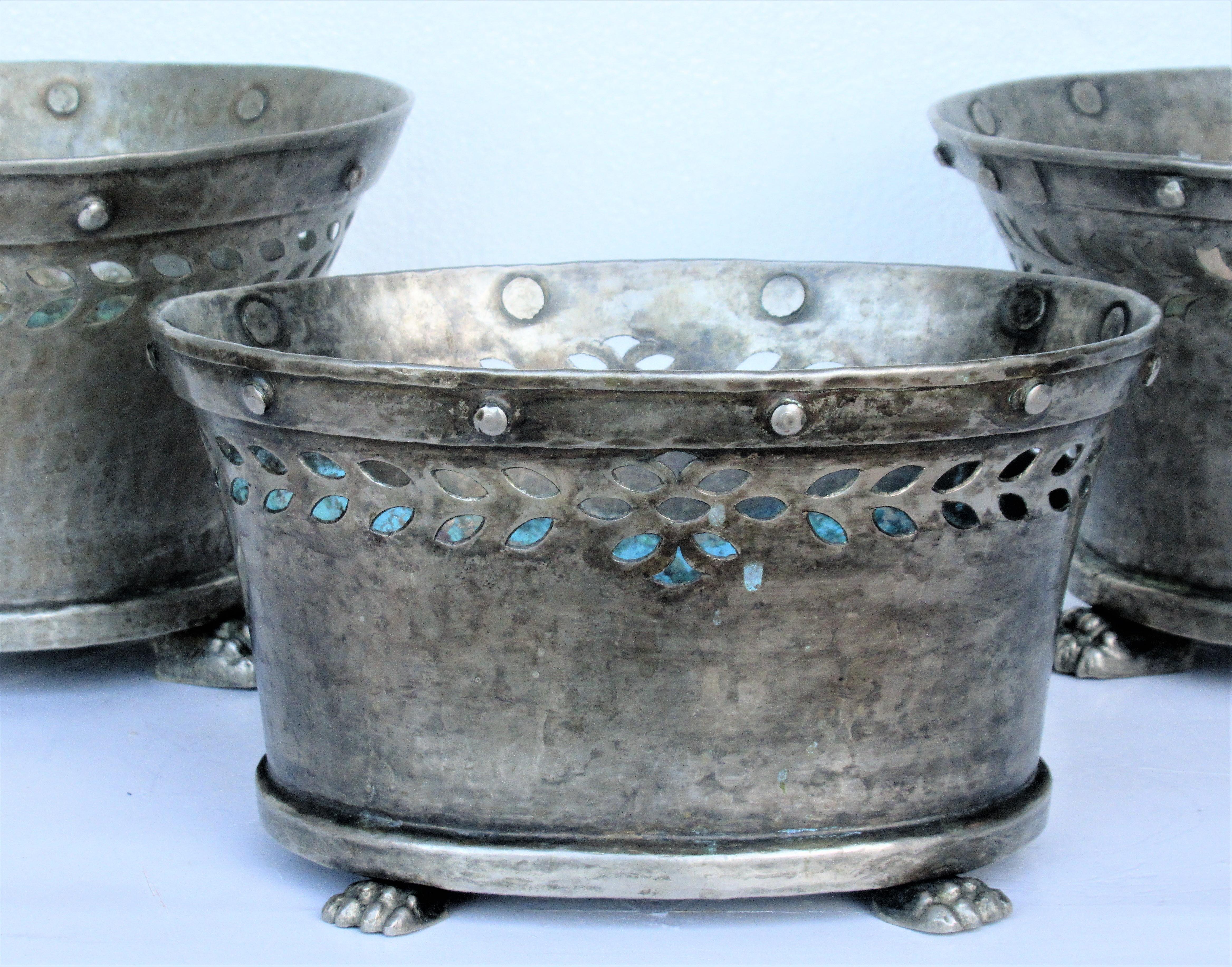 A group of three silver tinned bronze tabletop cachepot planters. The two flared round shaped ones are a near pair with the exception of different shaped cutouts along upper portion of bowl and one being very slightly larger. The other cachepot is