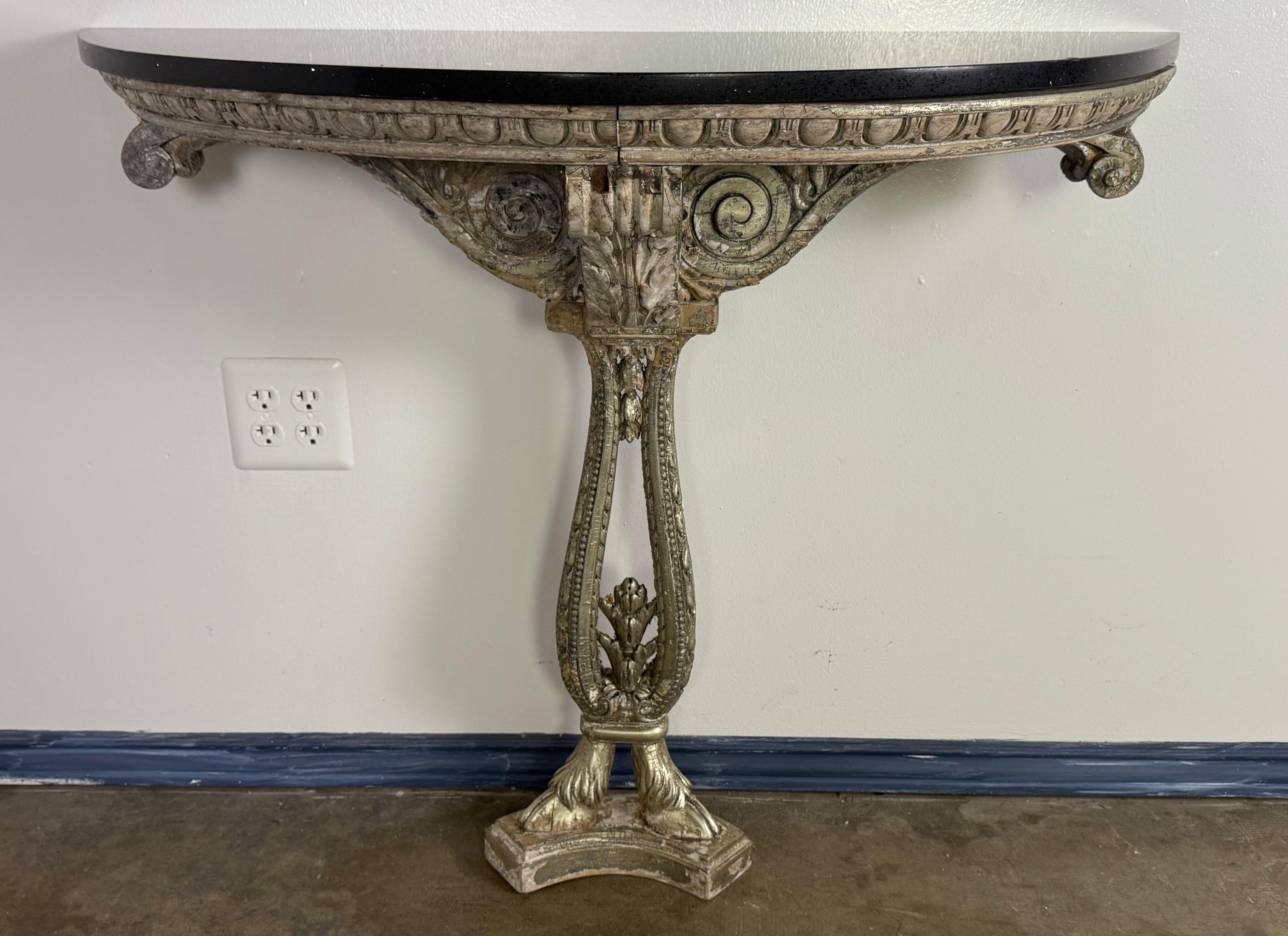 A striking Italian wall-mounted console table, richly carved and silver-gilt with classical motifs and a bold, sculptural presence. Dating to the early 20th century, this piece is a beautiful example of Italian neoclassical revival, blending refined