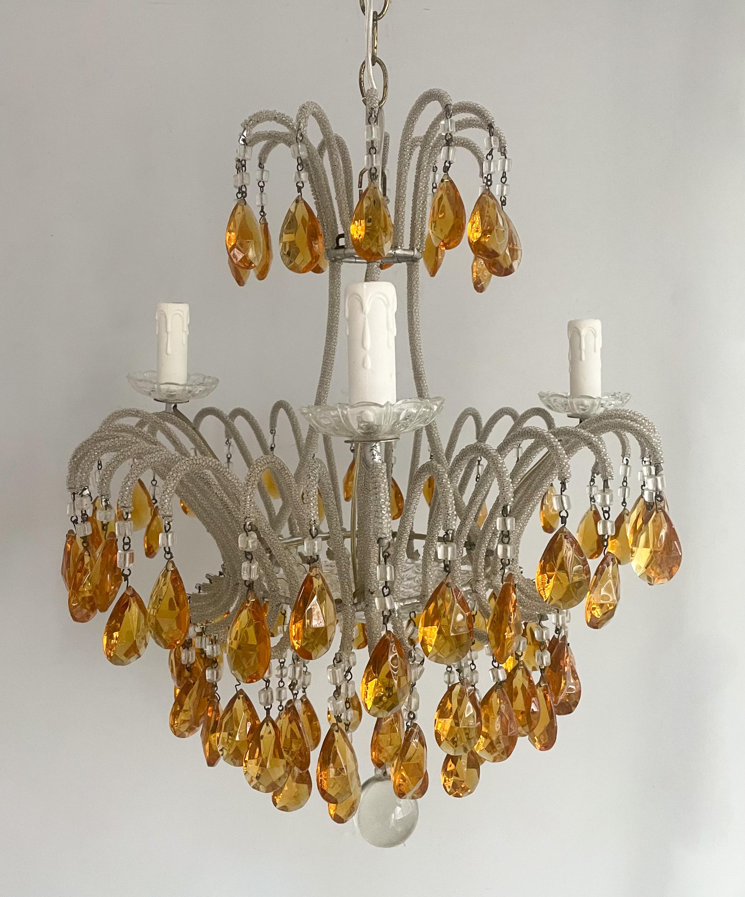 Wonderful, Italian 1940s crystal beaded chandelier with light amber faceted prisms.

The chandelier consists of scrolled iron frame wrapped in tiny silvered glass beads and decorated with macaroni glass beads and light amber prisms. There’s a