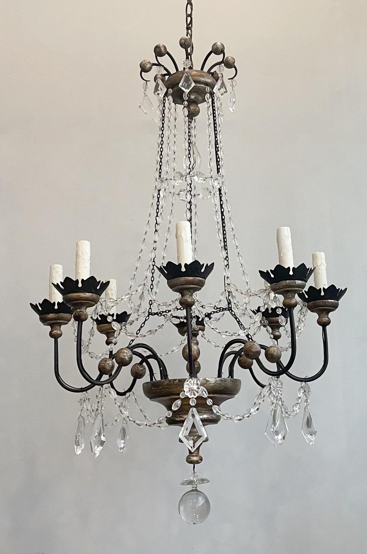 Gorgeous, Italian silver-leafed wood, iron and crystal chandelier.

The chandelier features a silvered wood base and top crown held together by metal chains and crystal bead strands. 

The chandelier is wired, and in working condition, it requires