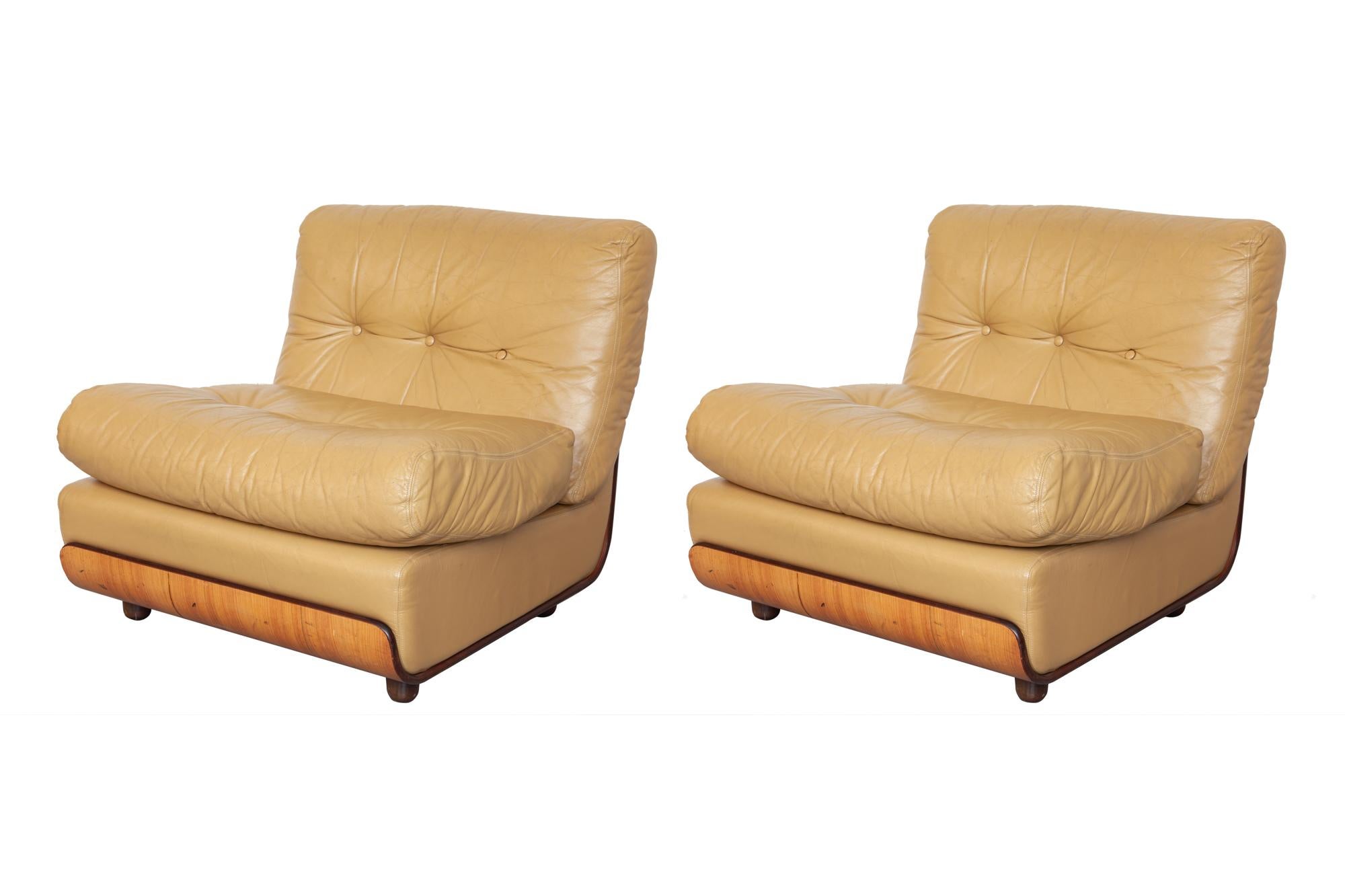 Set of two Italian lounge chairs marked Aemmeci Sezionne. Sand colored leather cushions and bentwood frame, rounded cylindrical wooden feet. The design is of a similar style to the classic Mario Bellini and Gaetano Pesce Amanta chairs.
Dimension: