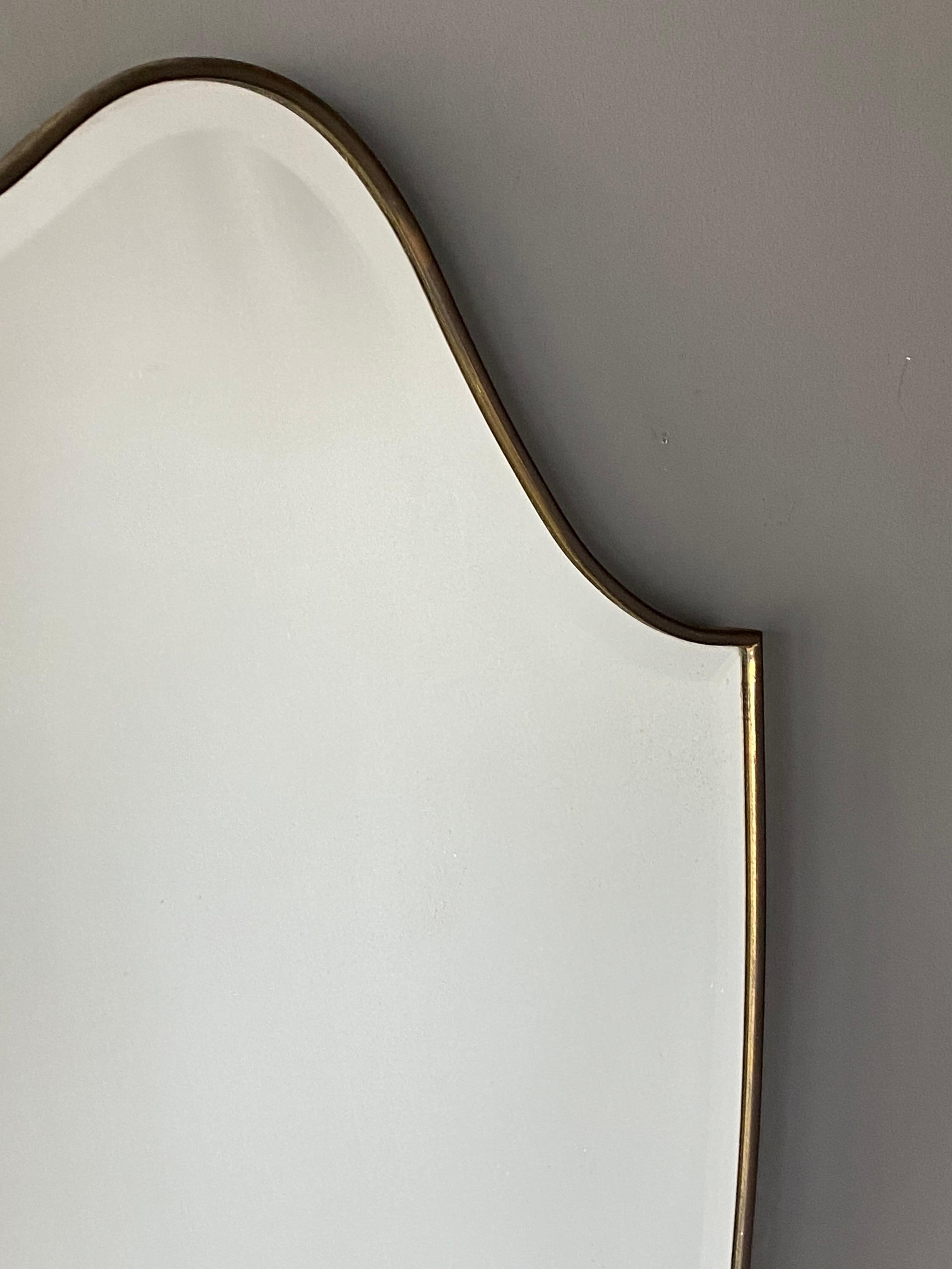 A large wall mirror, produced in Italy, 1940s-1950s. Cut mirror glass is framed in brass. 

Other designers of the period include Gio Ponti, Fontana Arte, Max Ingrand, Franco Albini, and Josef Frank.