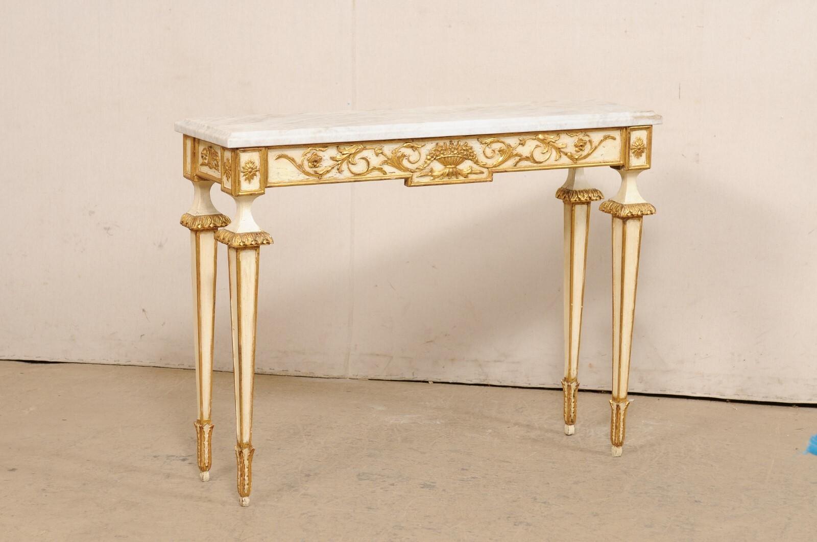 An Italian slender console table with new stone top. This vintage table from Italy has a new rectangular-shaped quartzite top with beveled edges, atop an apron which is embellished in a carved scrolling foliate motif, and flowers carved and framed