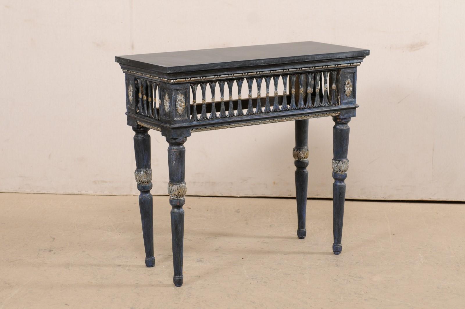 A beautiful Italian console table with pierced skirt and slate stone top from the early 19th century. This antique table from Italy is topped with a rectangular-shaped honed black slate slab, which rests above a fabulously pierce-carved apron, along