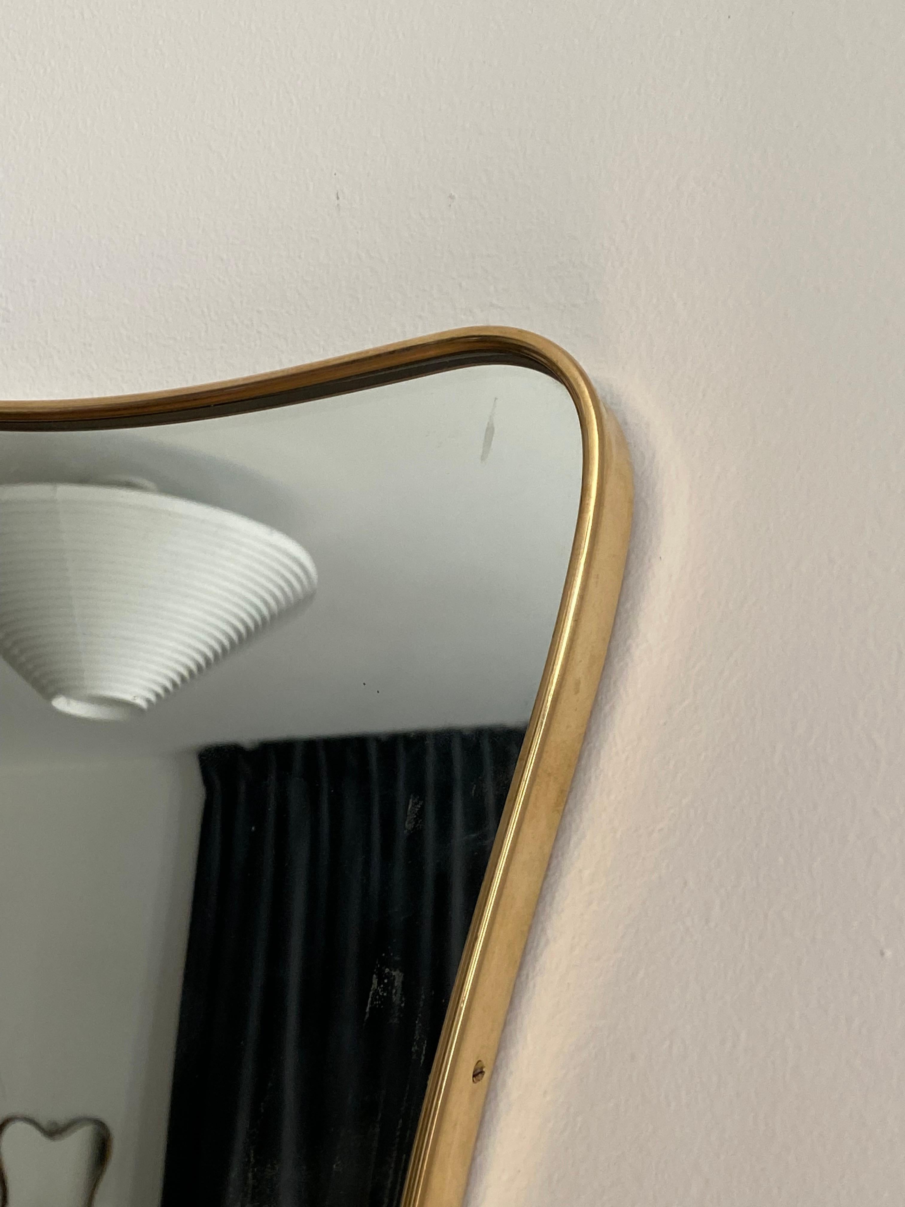 A small organic wall mirror, produced in Italy, 1950s. Organically cut mirror glass is framed in ribbon-shaped brass.

Other designers of the period include Gio Ponti, Fontana Arte, Max Ingrand, Franco Albini, and Josef Frank.
