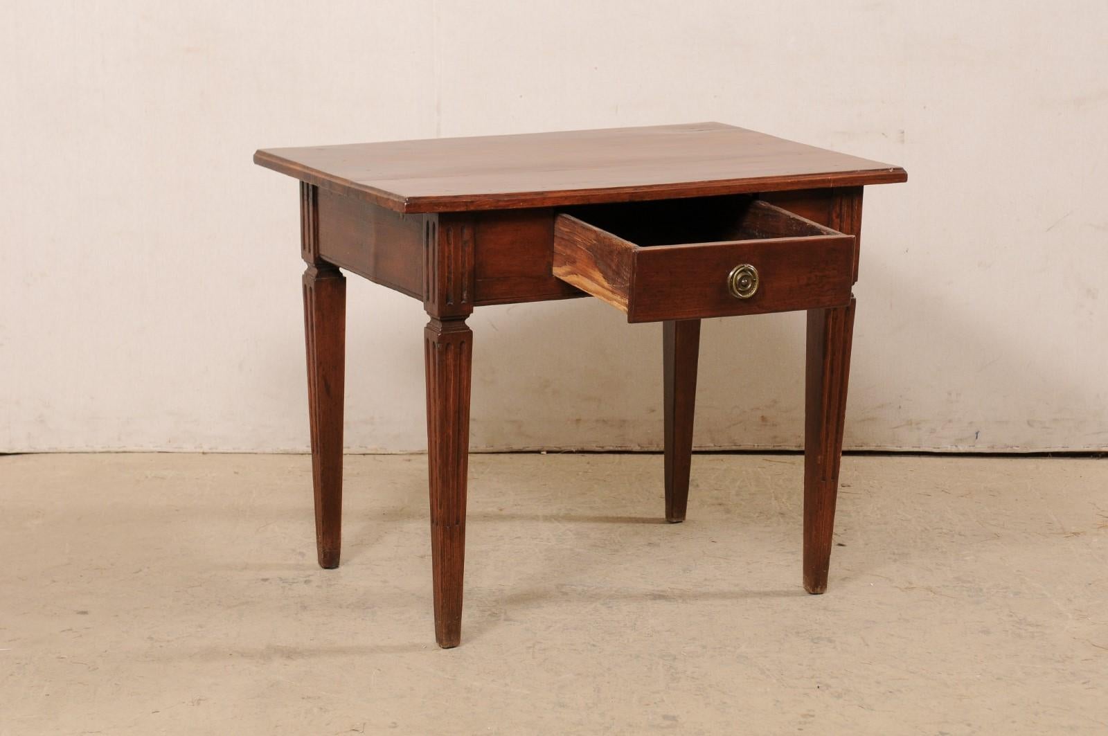 An Italian carved-wood table with drawer from the 19th century. This antique table from Italy has a rectangular-shaped top, which overhangs an apron which houses a single drawer at one side (minimally adorn with a brass ring pull, and clean,