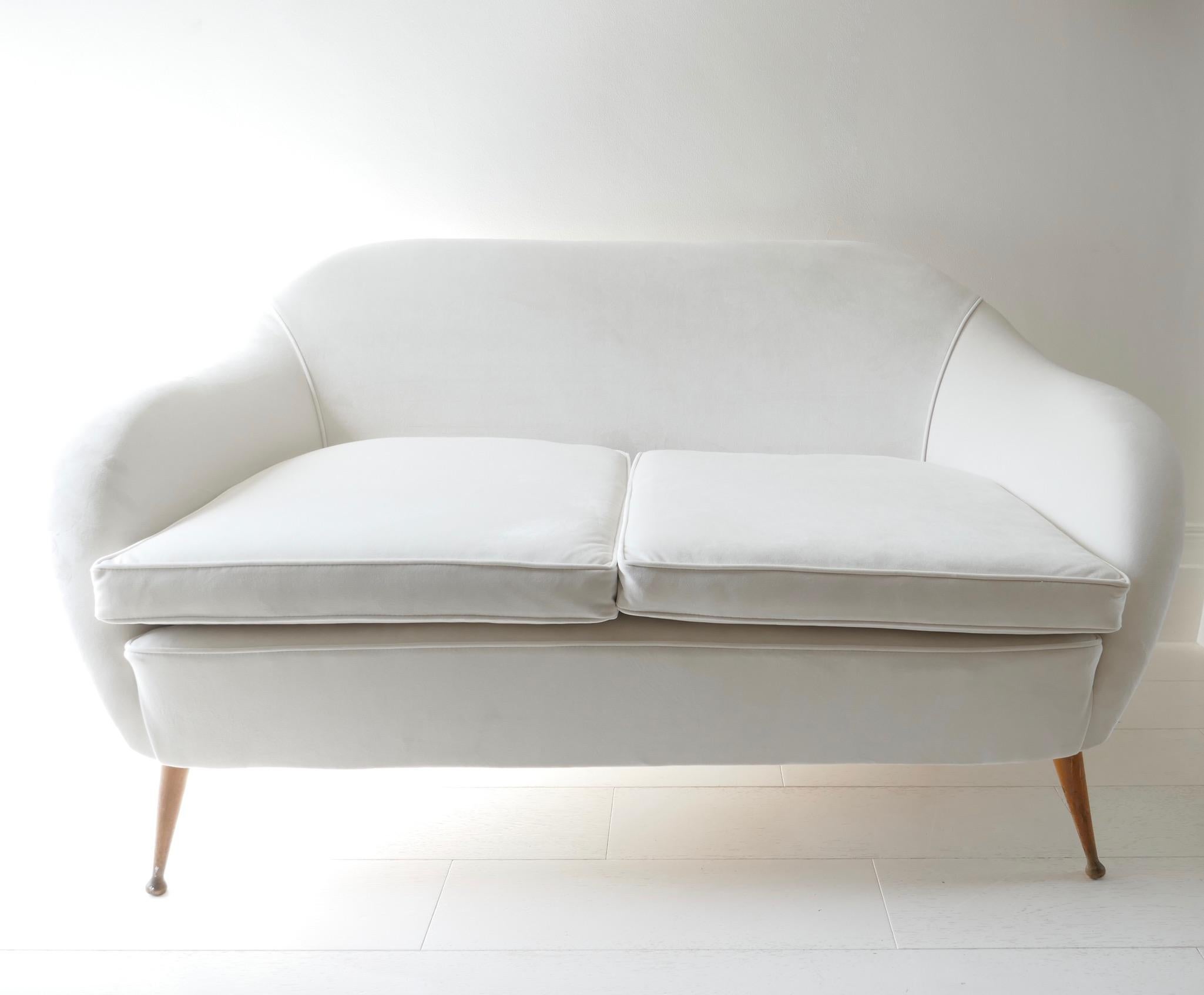 Italian two seat sofa, 1950s, reupholstered in white velvet with wooden legs.