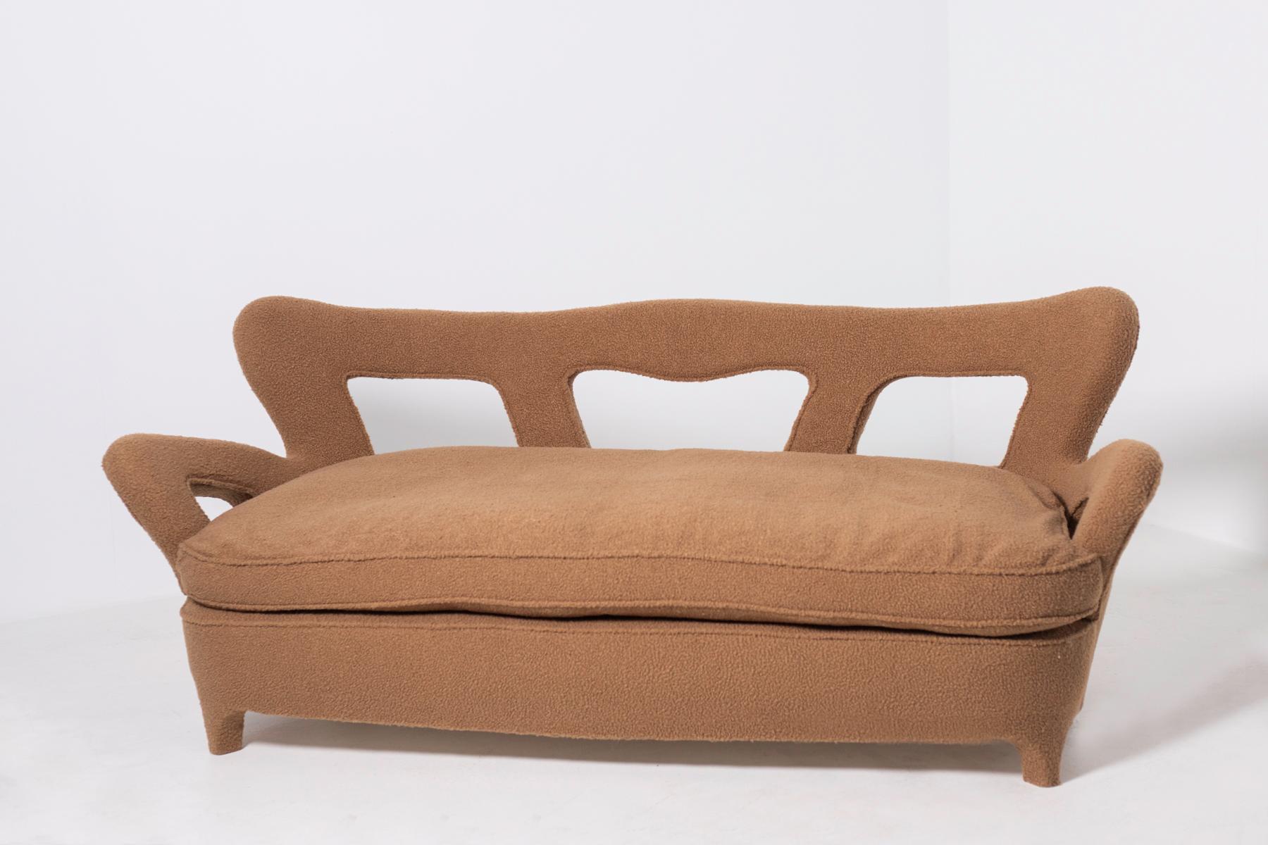 Rare sofa attributed to Carlo Enrico Rava from 1940. The sofa has been restored in a beautiful bouclè fabric very fashionable in this period. The fabric is brown which gives the seat warmth and softness. The peculiarity of the sofa is its shape, in