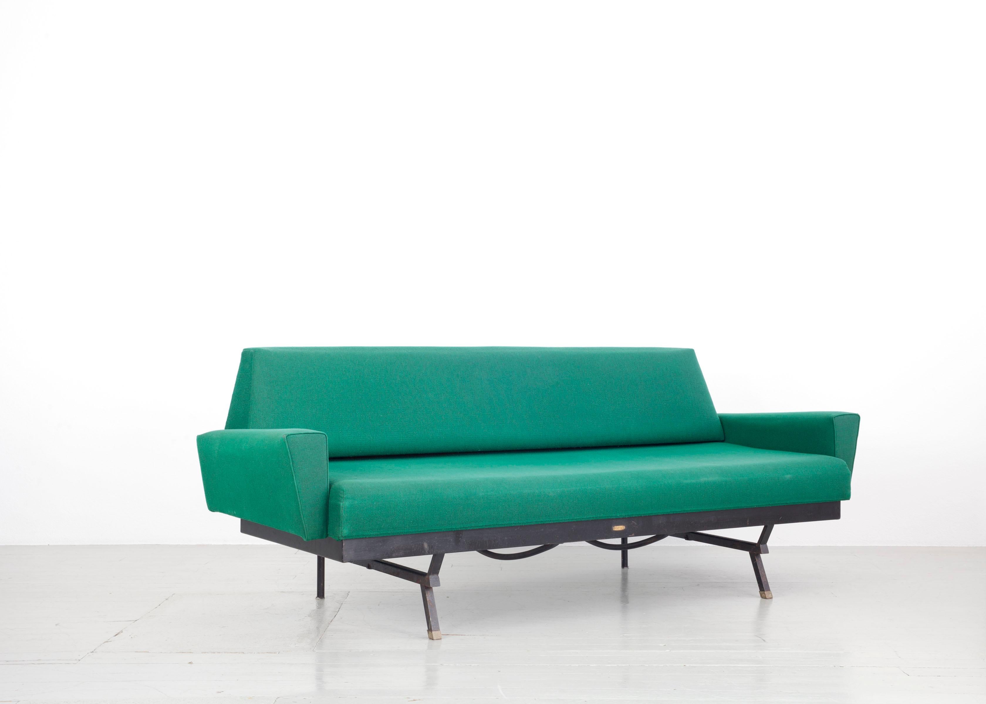 This Italian sofa bed was designed in the 1950s. The shapes lend elegance and modernity to the otherwise quite minimalist design. The seat is foldable, this way the sofa can serve as a bed, however, the mattress is missing. The original green cover