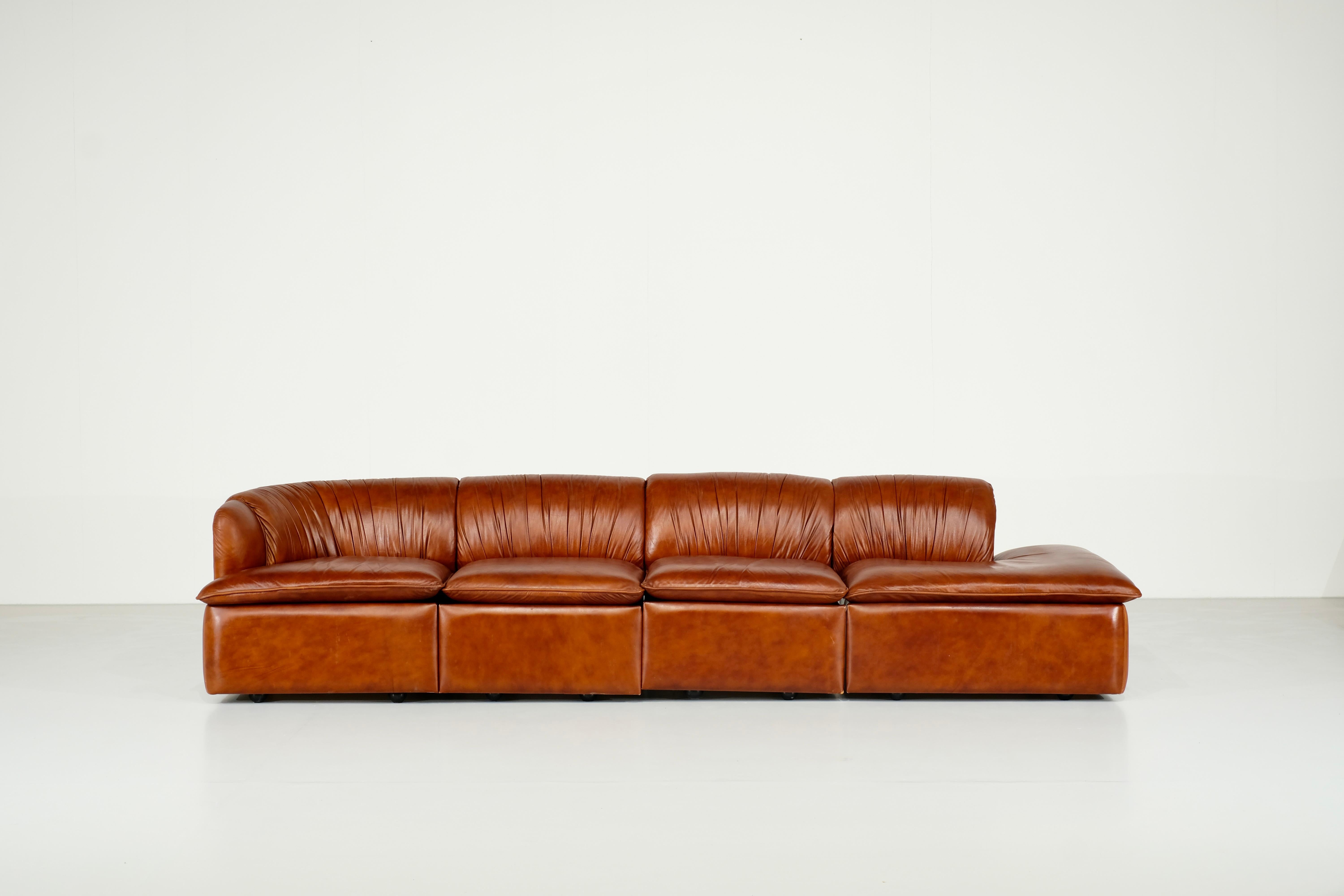 Amazing cognac leather sofa from Italy in the 1960s,

This sofa is made of 4 parts that fix together thanks to hooks placed below the seats.
The last part of the sofa is modulabe and not fixed to the 3 other parts.

The leather is in really good
