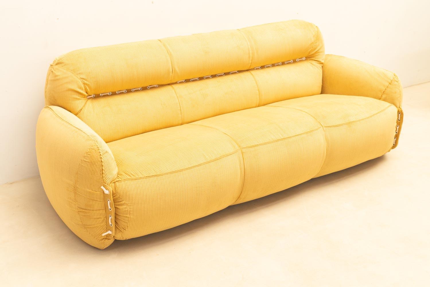 A very comfortable design with eye-catching colors. This 1970s Italian sofa has been recently upholstered in vibrant yellow corduroy. Its generous shape invites you to sit and lounge, offering ultimate comfort. Rope detailing along the armrests and