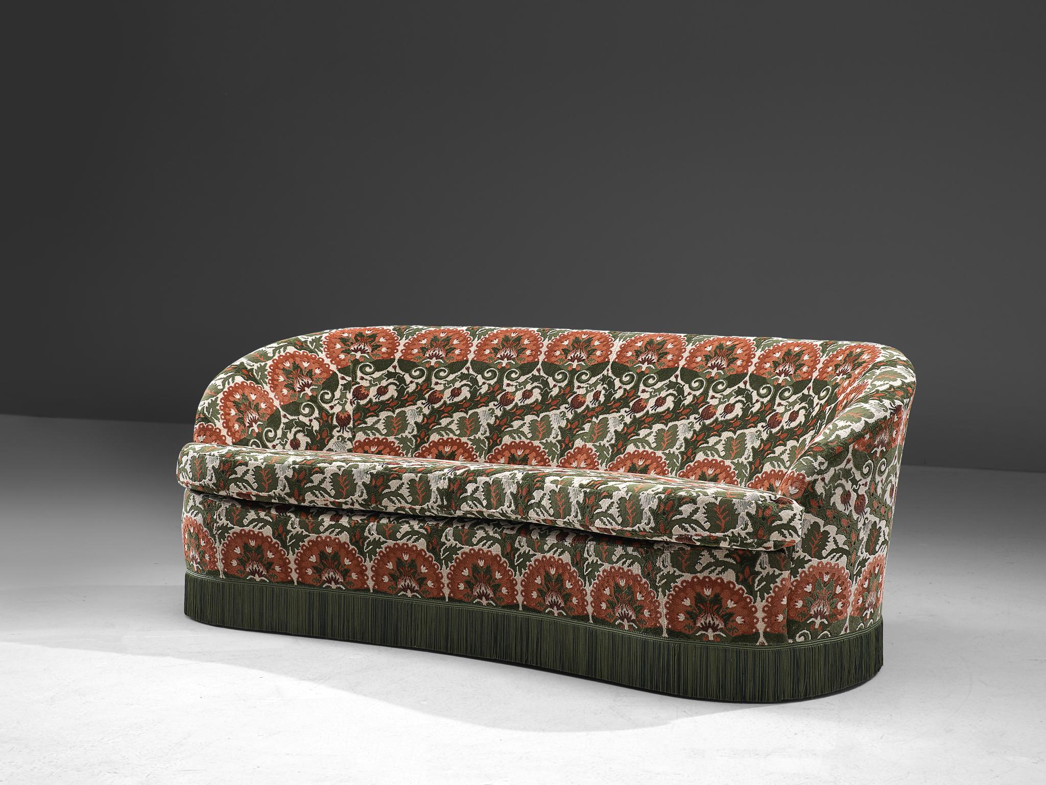 In the manner of Gio Ponti, three-seat sofa, floral fabric and wood, Italy, 1940s.

Elegant and feminine sofa designed in the style and time of Gio Ponti with a richly colored upholstery and a Classic green skirt. This sofa features a curved, high