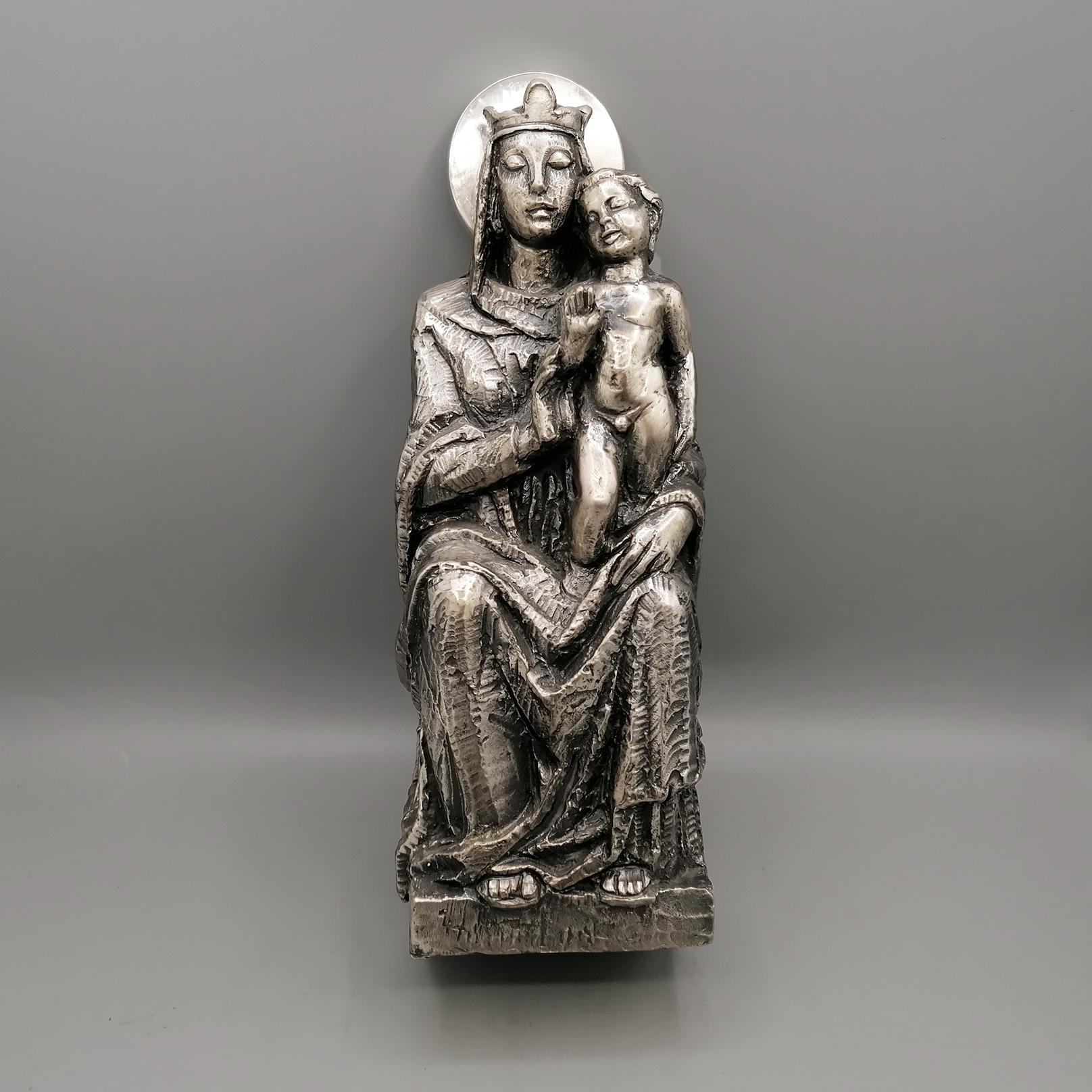 Hanging statue depicting the Madonna and Child blessing, seated on the throne.
It was made with the sand/earth casting technique, finely chiseled and subsequently burnished and treated with antioxidant paint.
Sand/earth casting consists of pouring