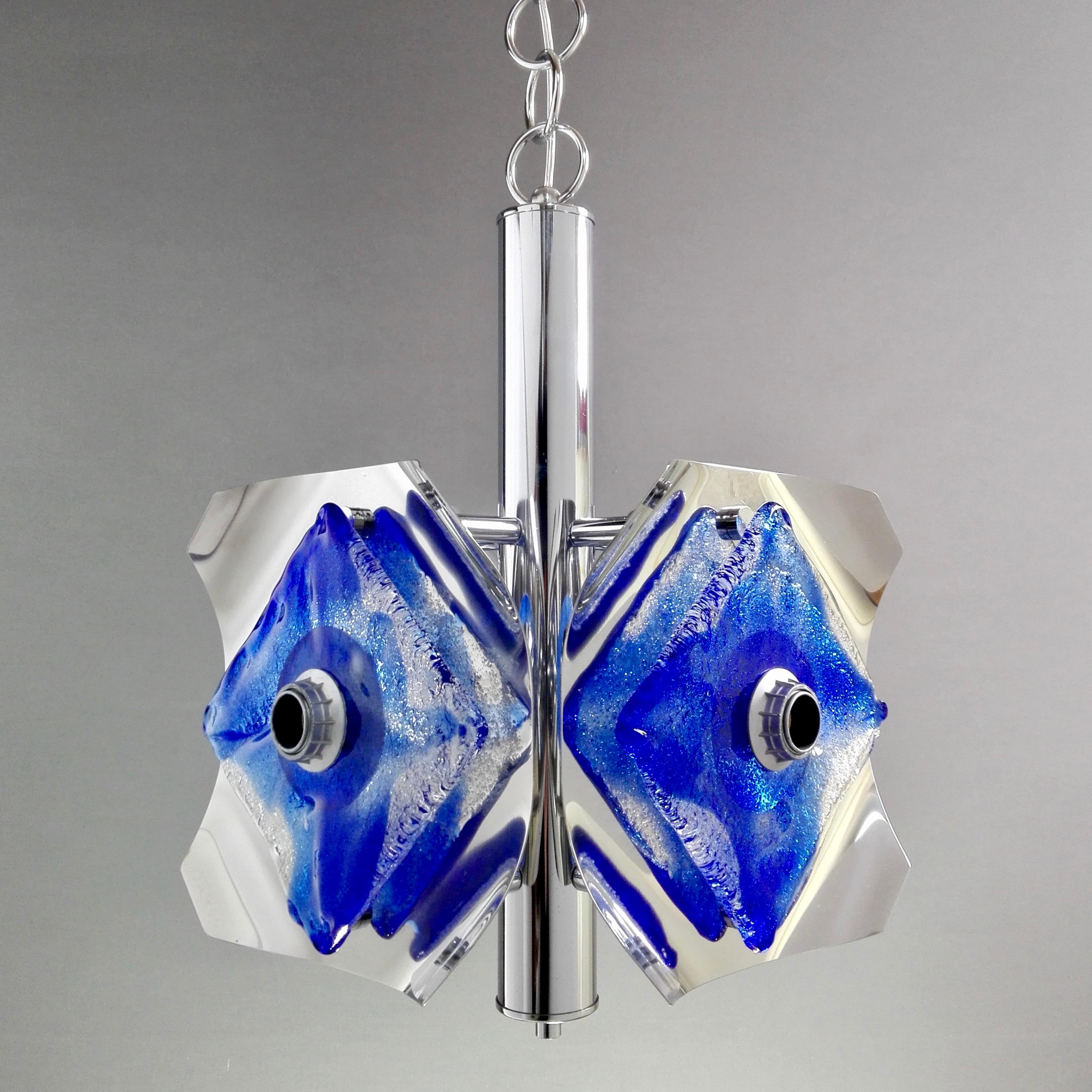 Dazzling vintage Space Age four-light pendant lamp. Works 110-240 volts. There is no trade mark on the lamp, however, the type of glass processing is attributable to the production of Mazzega Murano. Nice chrome frame with reflecting elements and