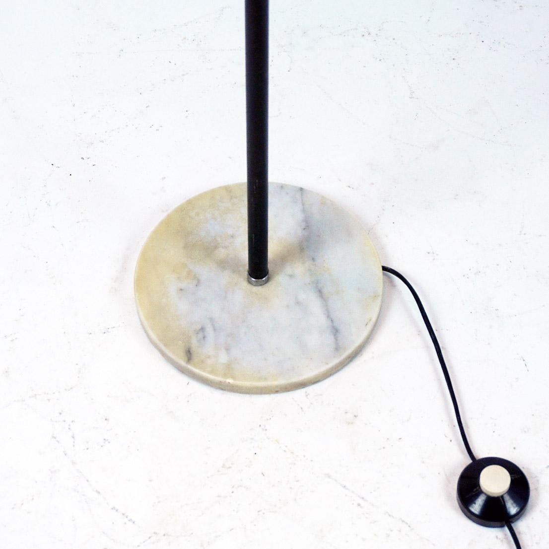 This amazing Space Age Spot floor lamp has been designed and manufactured in Italy 1960s. It features a black metal stem, a marble base and three adjustable aluminum and black lacquered metal spots. 
The wires are mounted in the interior of the