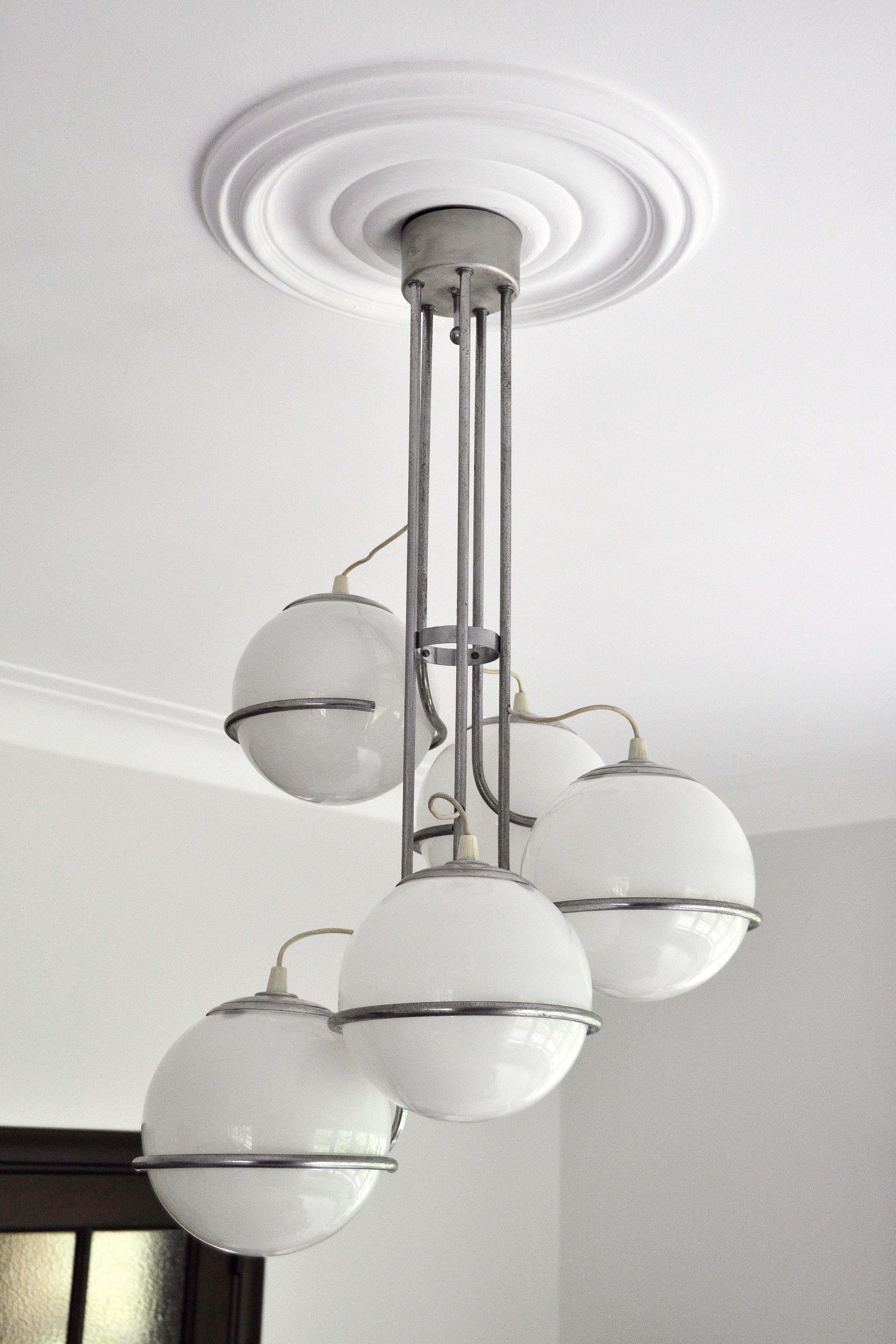 A very spectacular cascading globe chandelier attributed to Gino Sarfatti. Original 1960's model. Made out of a chromed steel structure holding 5 milk glass globes. Gives a beautiful diffuse light emission.

In perfect condition, the chrome