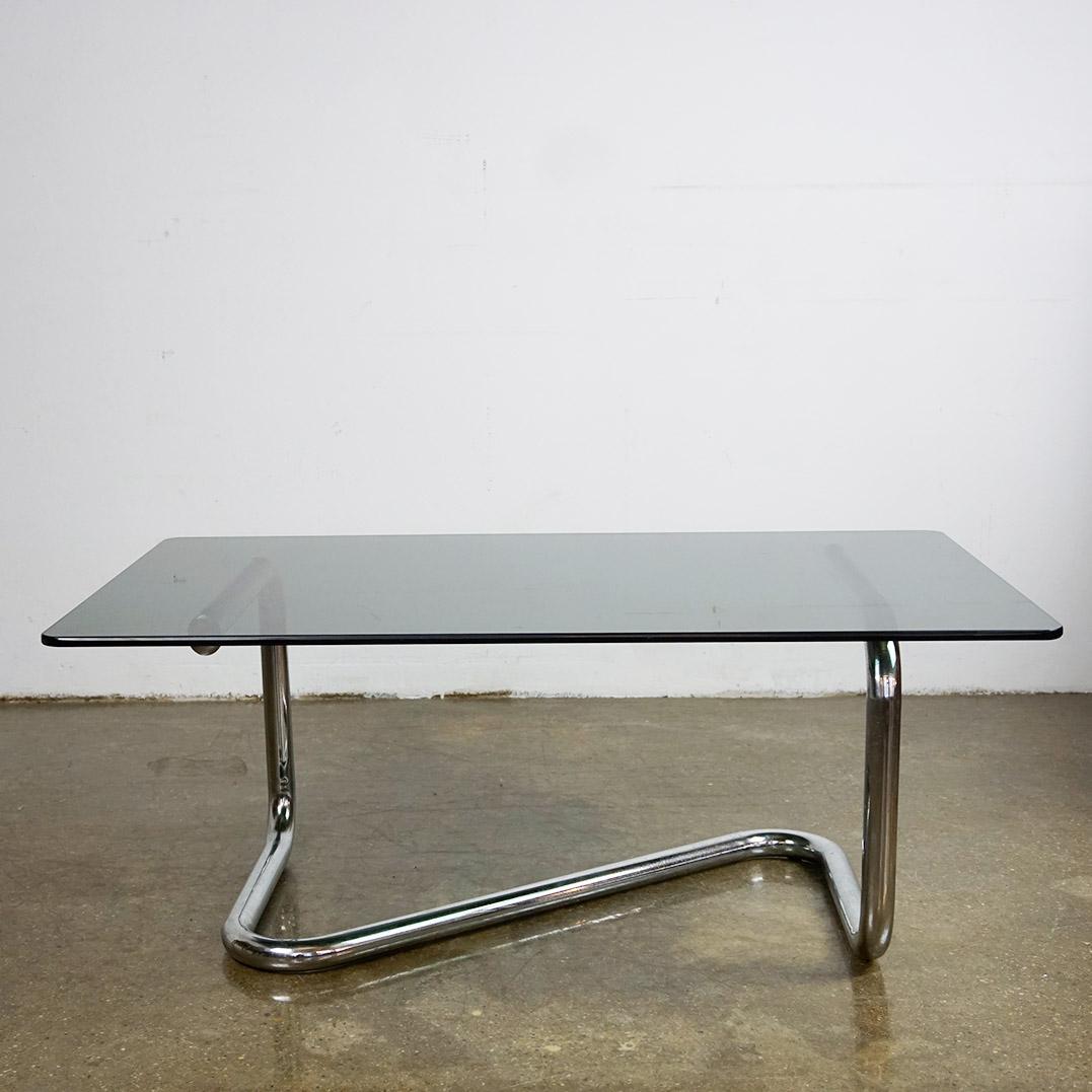 This fantastic midcentury Chrome and smoked glass coffee Table has been designed and produced in Italy in the 1970s. It features a tubular chromed base with a rectangular smoked glass top.
It´s style is very close to some Designs by Giotto