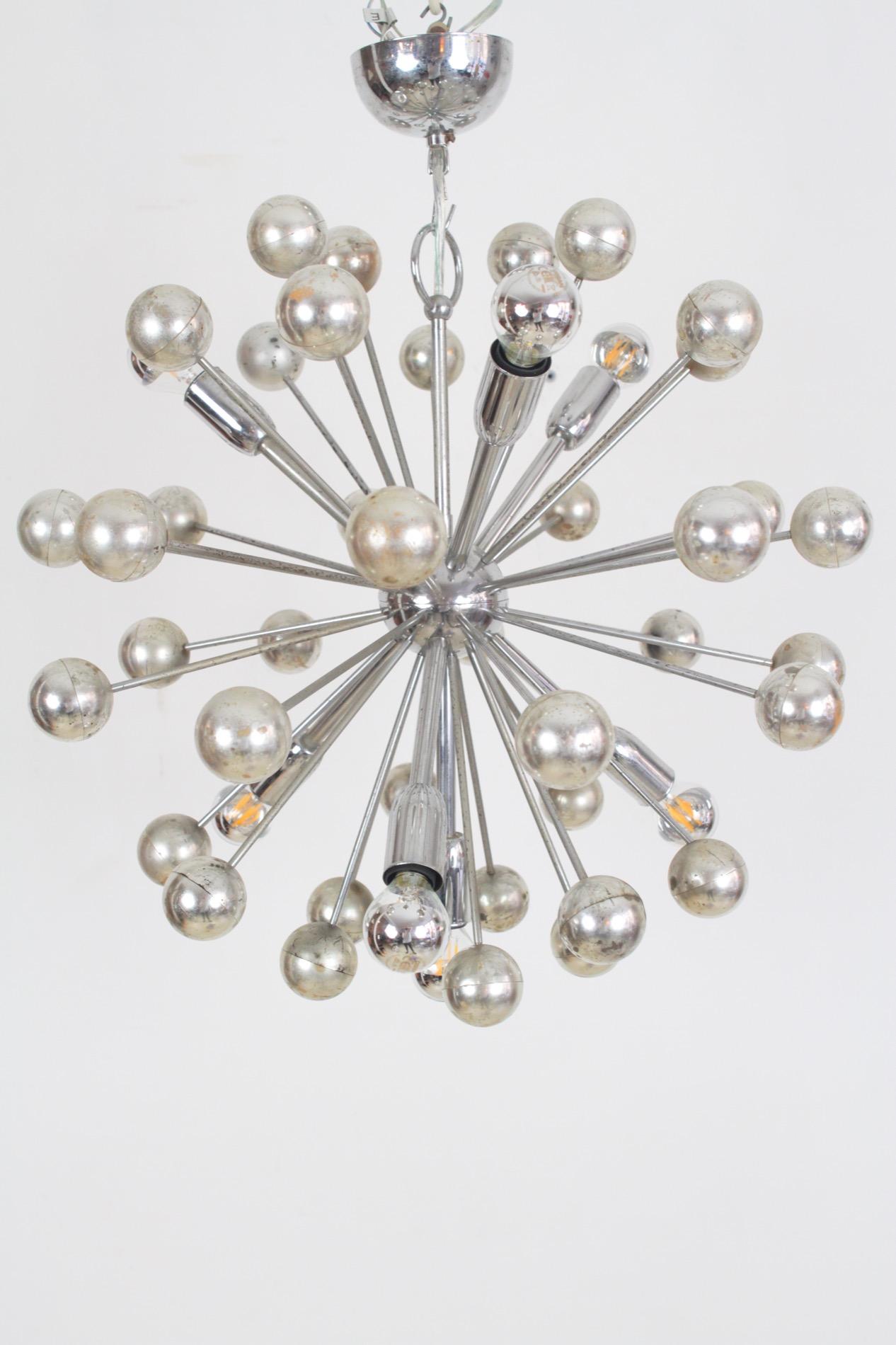 This amazing sputnik chandelier was produced in Italy in the 1970s. It features seven pieces of E14 chromed metal sockets, arms and body interspersed with chrome-plated plastic spheres. Your choice of bulbs will create different looks; we took the