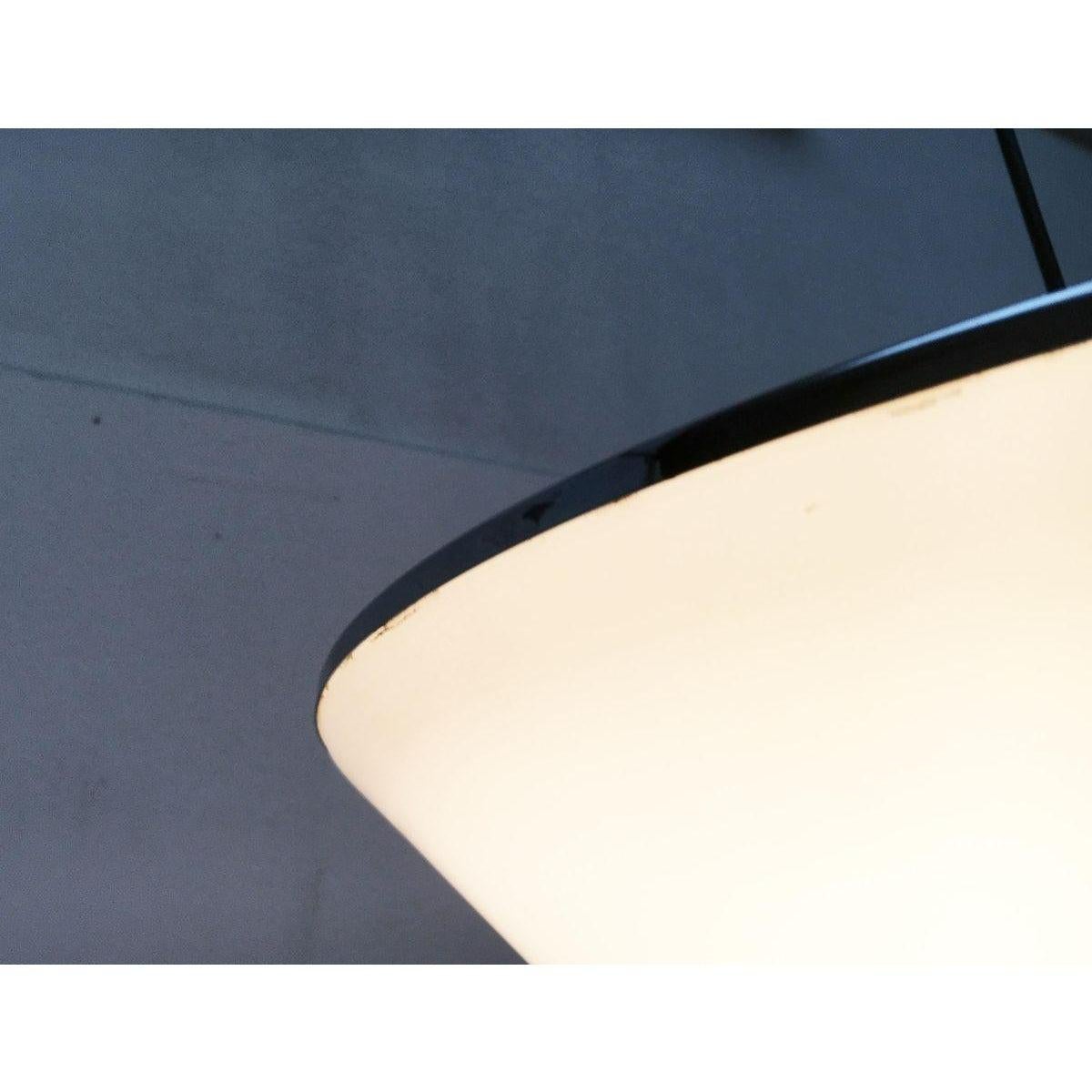 Rare version de la lampe suspendue Elpis de Guzzini.

Le bouclier en acrylique translucide forme un cône plat avec une pointe douce et arrondie. La particularité réside dans l'orientation inversée avec la pointe orientée vers le bas. Il est encadré