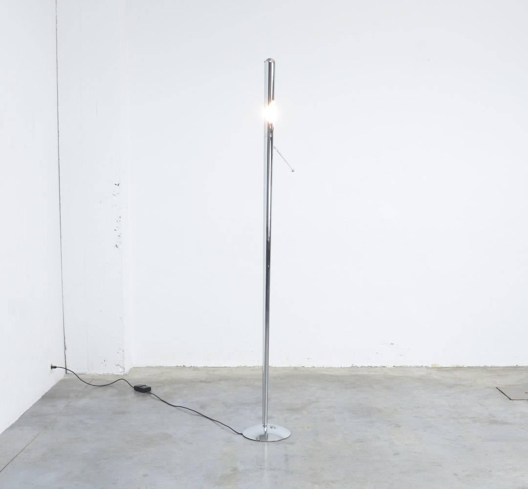 This special chrome floor lamp can be dated in the 1960s.
It is a simple chrome tubular lamp with some special details reminiscent of the space age: the small red ‘lights’ at the top of the lamp, the decorative handle and the convex chrome