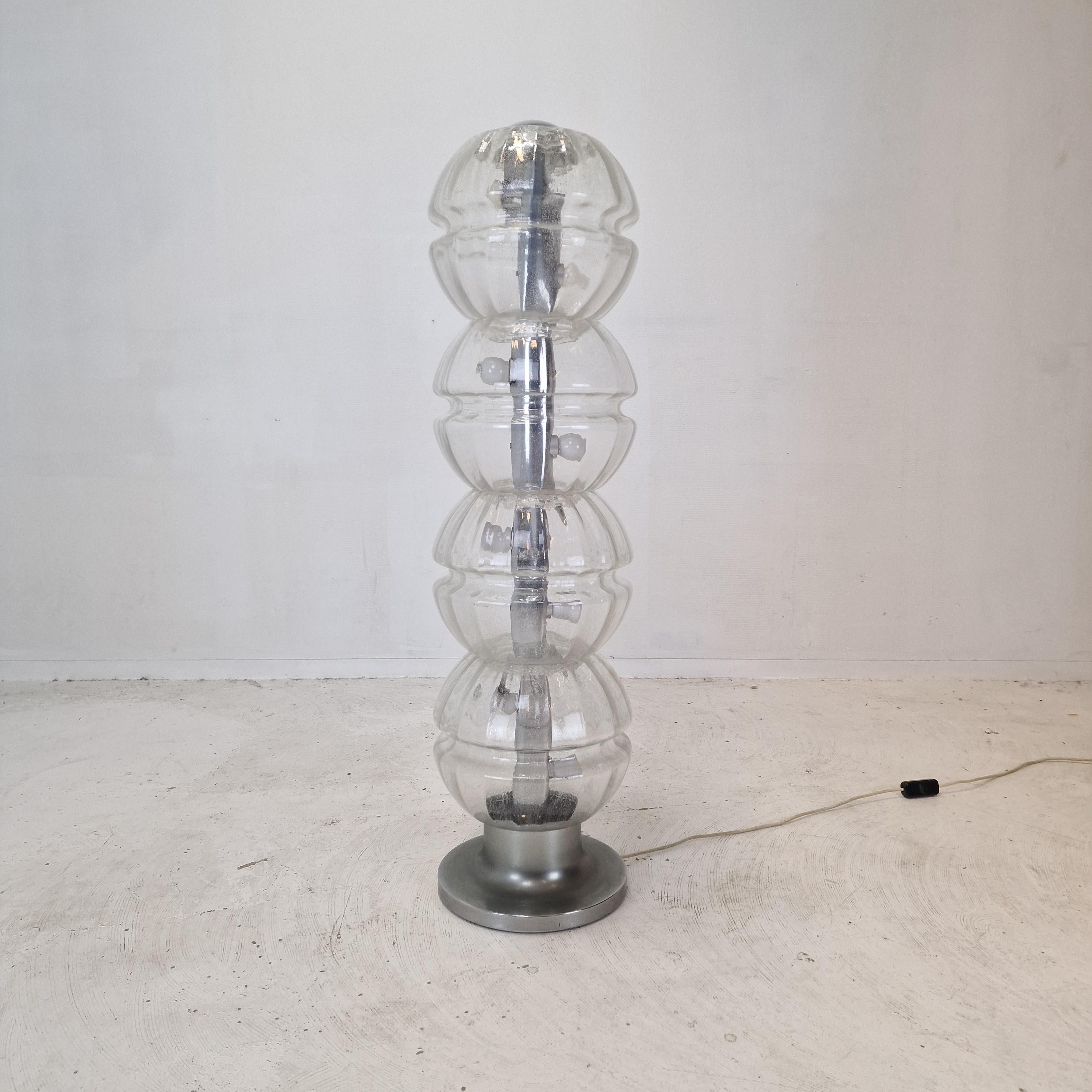 The present light is very rare and well preserved floor lamp, designed in the 1980's in Italy. 

Realized in four elements in rounded glass, with finishing details in chromed metal.
Every bulb has two lamp holders.

It produces a nice light and is