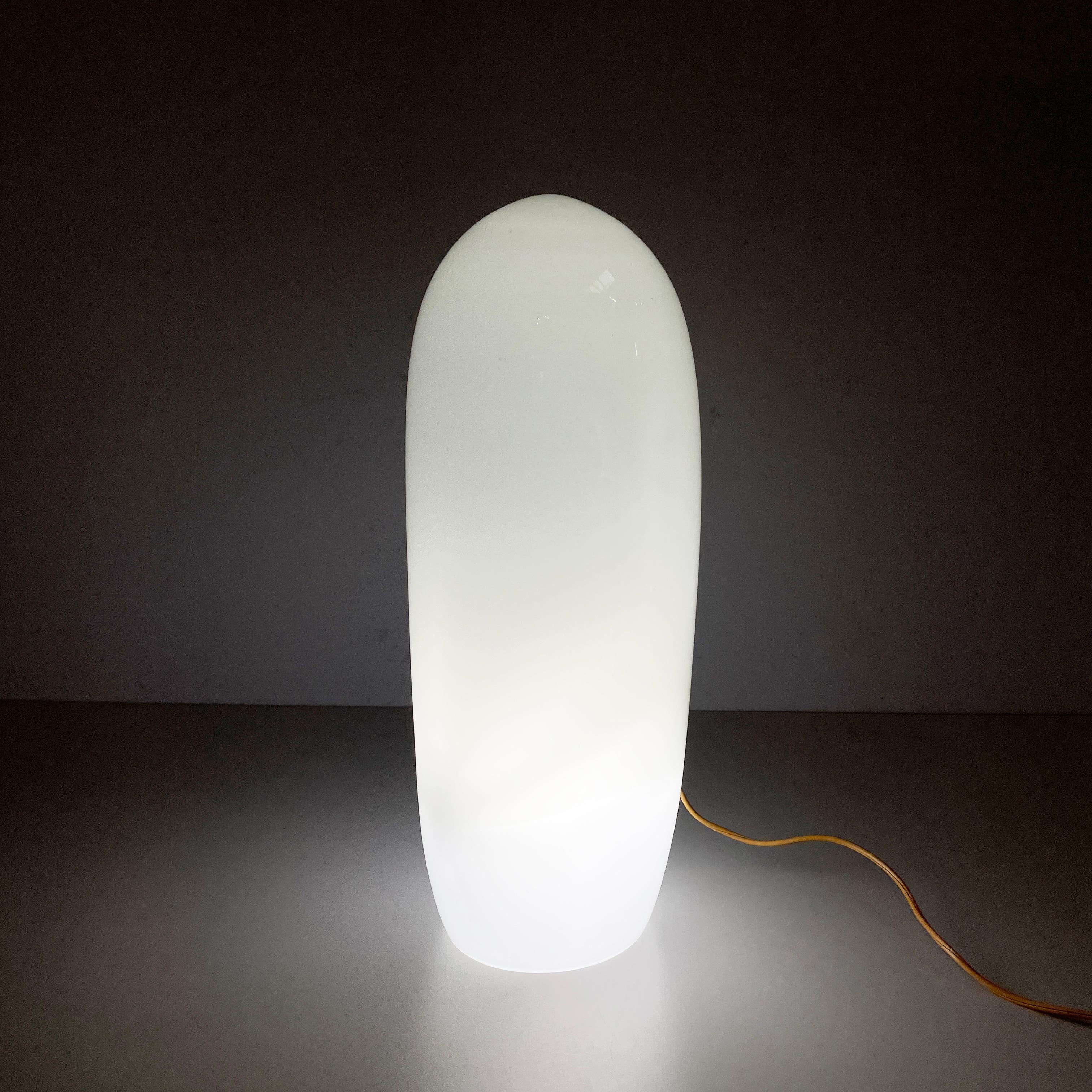 Lampe de table italienne en verre opalin de l'ère spatiale par Vistosi, 1970
Fantastique lampe de table avec une base ronde en verre opalin. La forme arrondie présente une légère courbe vers le haut. La base est ornée d'une bande décorative en verre