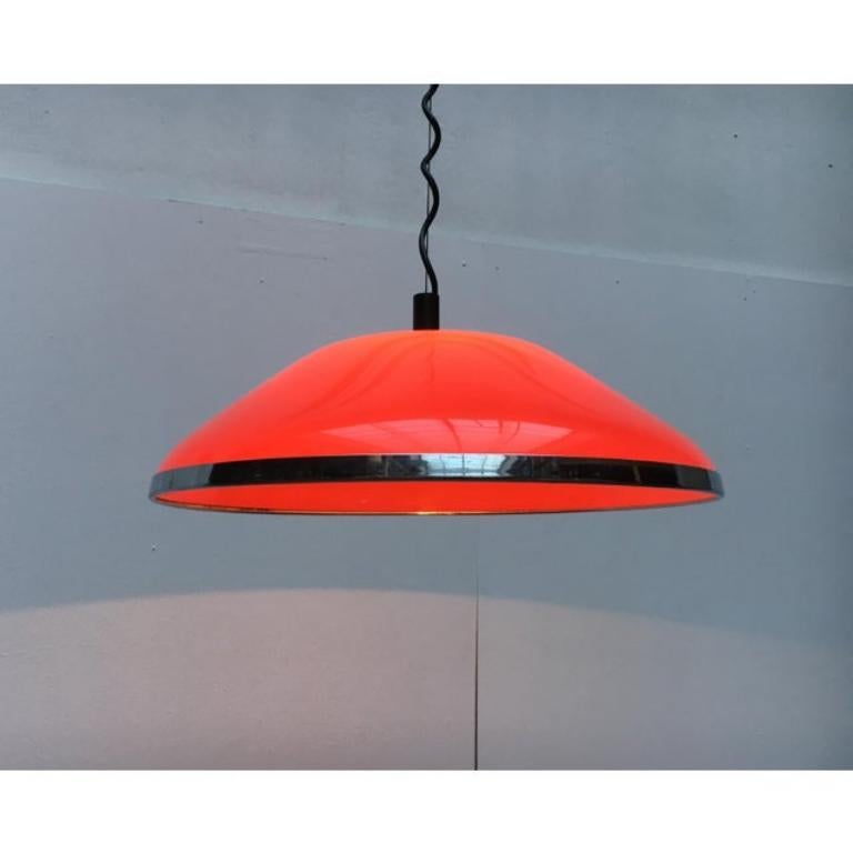Très rare lampe suspendue de Harvey Guzzini.

L'écran en plastique a la forme d'un cône plat et est conçu en rouge translucide. En dessous, l'écran est encadré par un large cadre chromé. Les éléments chromés typiques de la partie supérieure sont