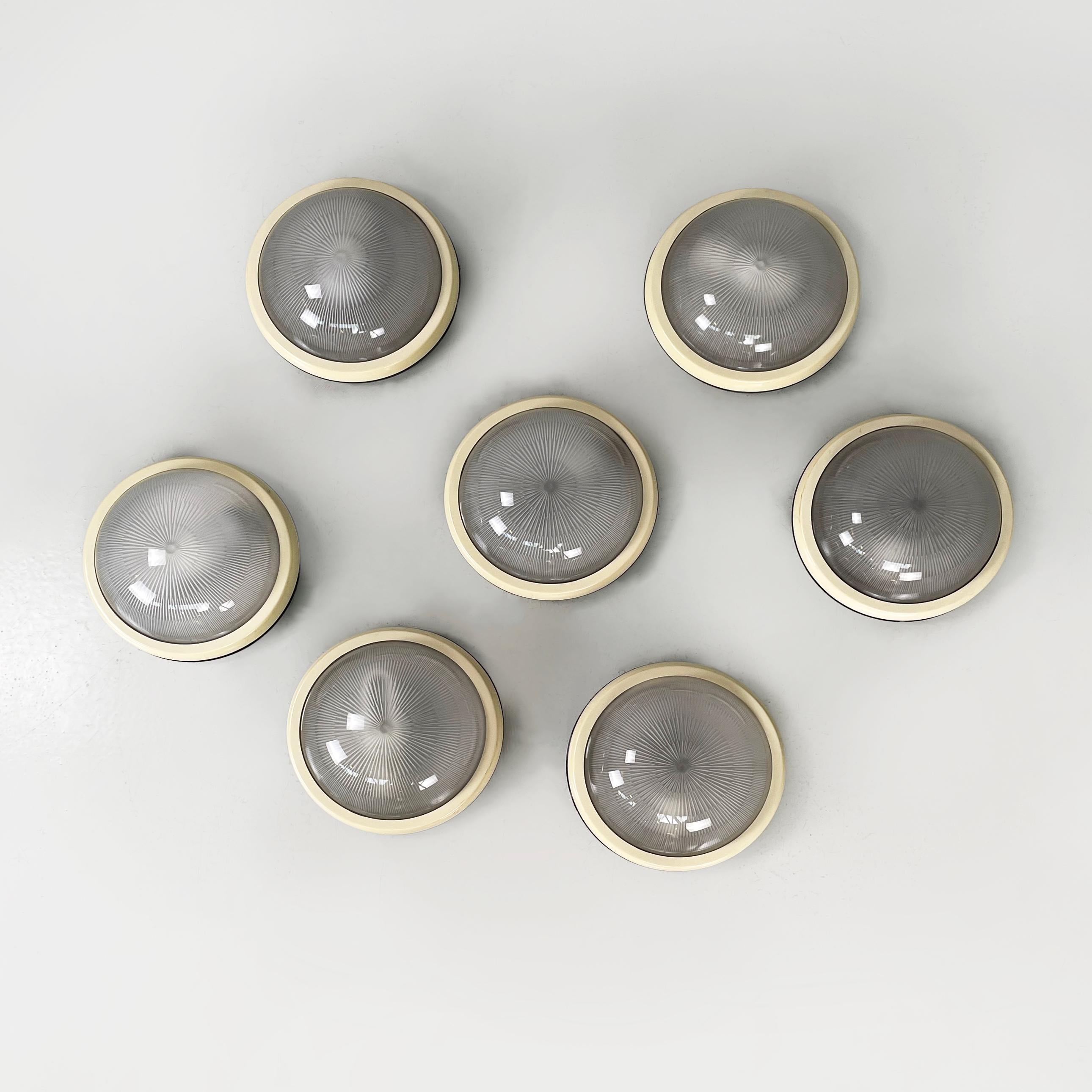 Lampade da parete rotonde dell'era spaziale italiana con  vetro stampato e plastica, anni '70
Set di 7 lampade da parete con diffusore a semisfera in vetro stampato. La struttura della base rotonda è in plastica beige con finitura lucida e nera con