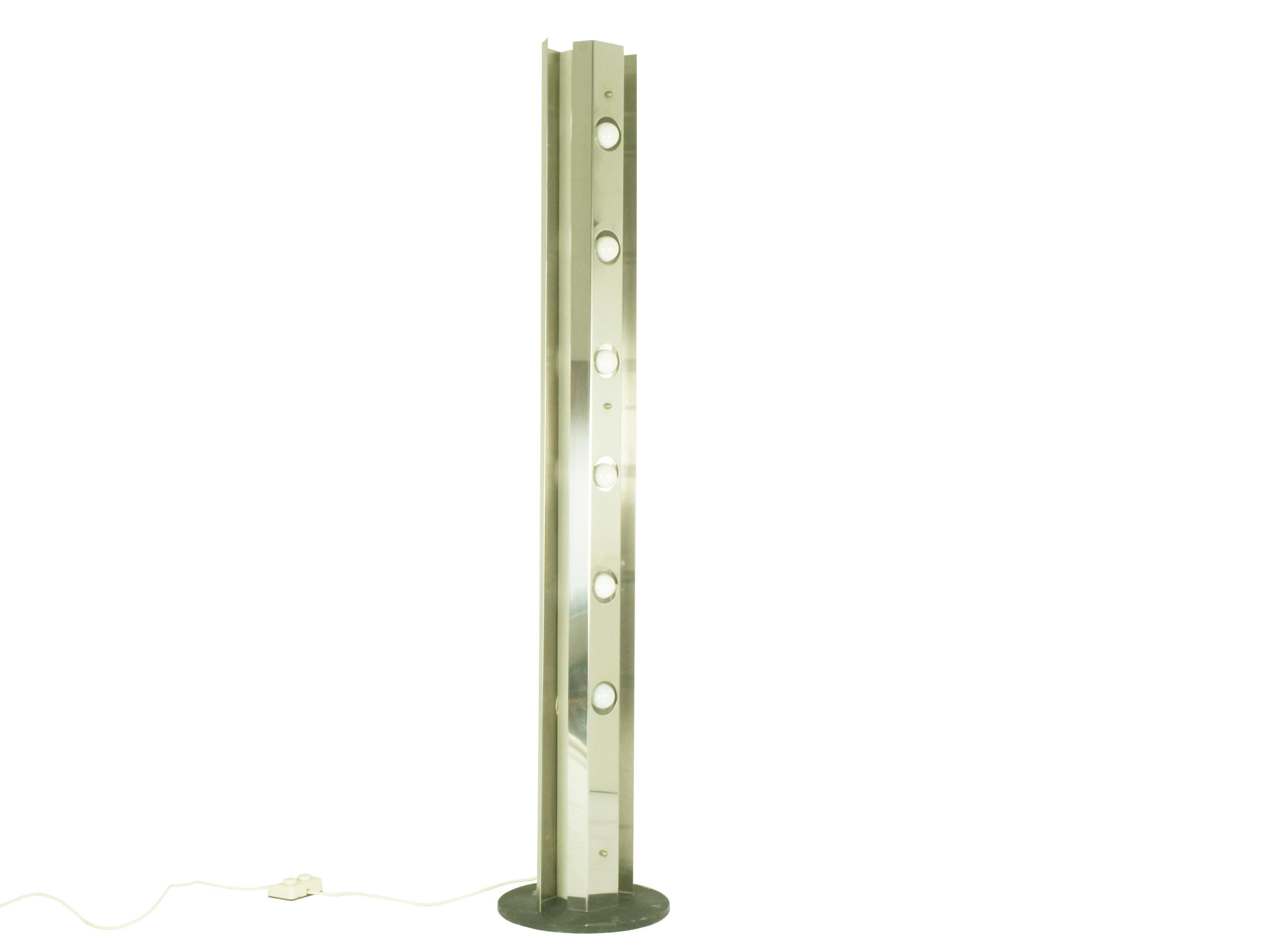 This floor lamp is made by two bent metal sheets with a circular base. It features 6 light sources that can be alternately switched on thanks to its double switch. The lamp remains in pretty good condition: visible 