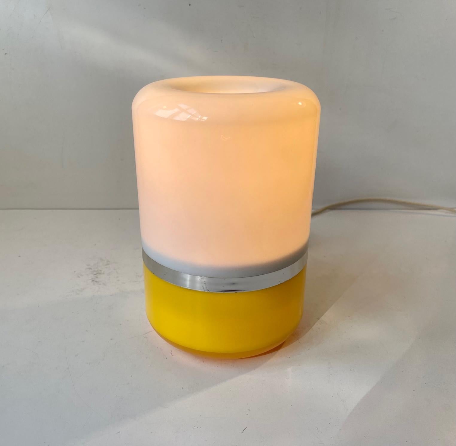 Small organically shaped/rounded table light made from white, yellow and chrome-plated acrylic/plastic. It was made in Italy during the 1970s probably bu Guzzini. Its original socket is E27 compatible and is has an on/off switch to its cord.