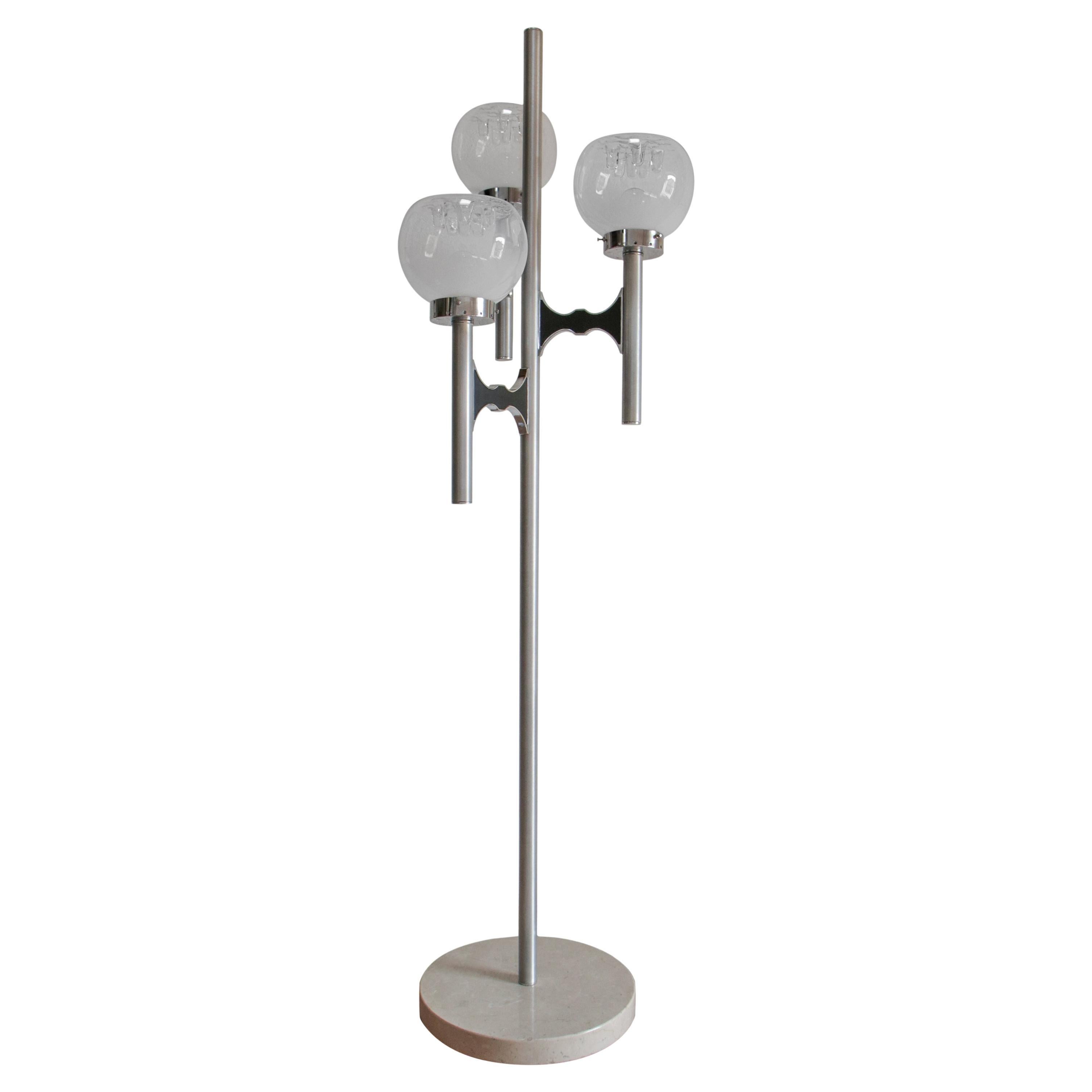 Elegante lámpara de pie de tres luces Italia Mid-Century Modern atribuida a Gaetano Sciolari, de la década de 1970.
Estructura de acero cromado, aluminio cepillado y base de mármol. Los vasos son de cristal soplado de Murano, según Mazzega. Un