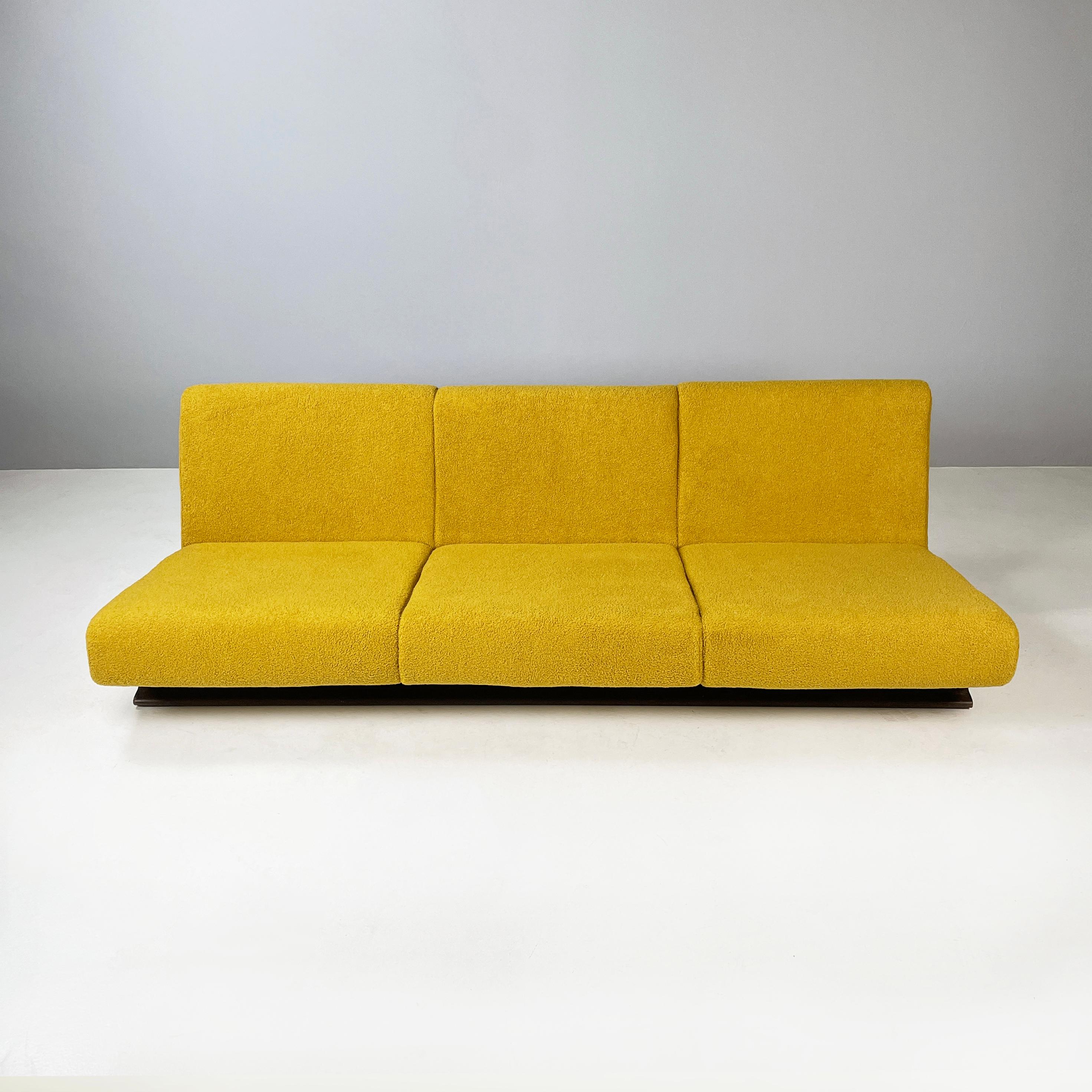 Italian space age Three-seater sofa in yellow fabric and black wood, 1970s
Three-seater sofa with squared seat and back, padded and covered in yellow teddy fabric. The legs are two strips made of black painted wood.
1970 approx.
Good condition, the