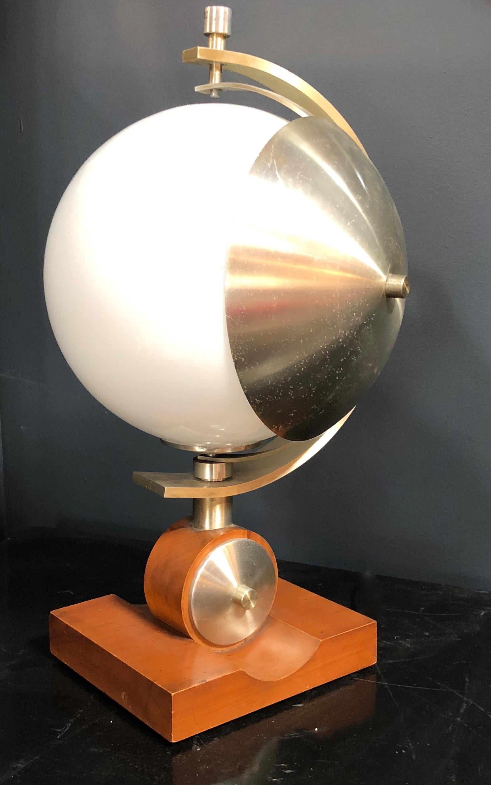 Space Age bowl table lamp with opaline white glass and metal turning part with solid wooden base.
Italian turn able table lamp, metal parts, lacquered wood base and opaline glass, good conditions overall, base sizes H 2
